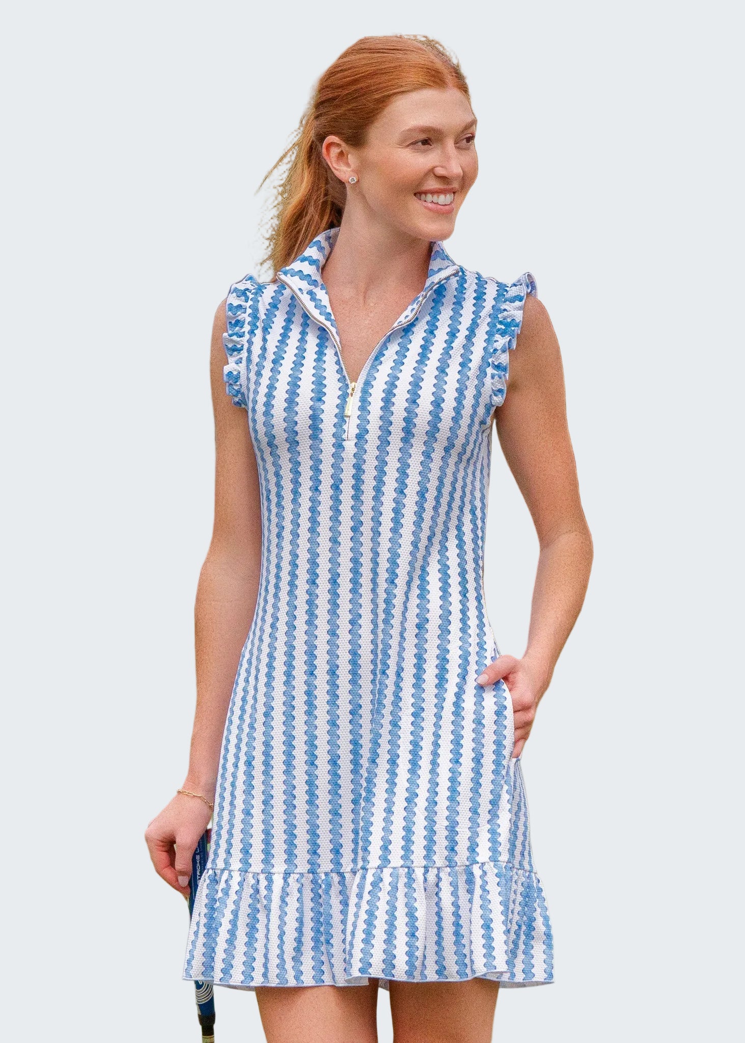 Woman wearing a blue and white striped dress on a golf course
