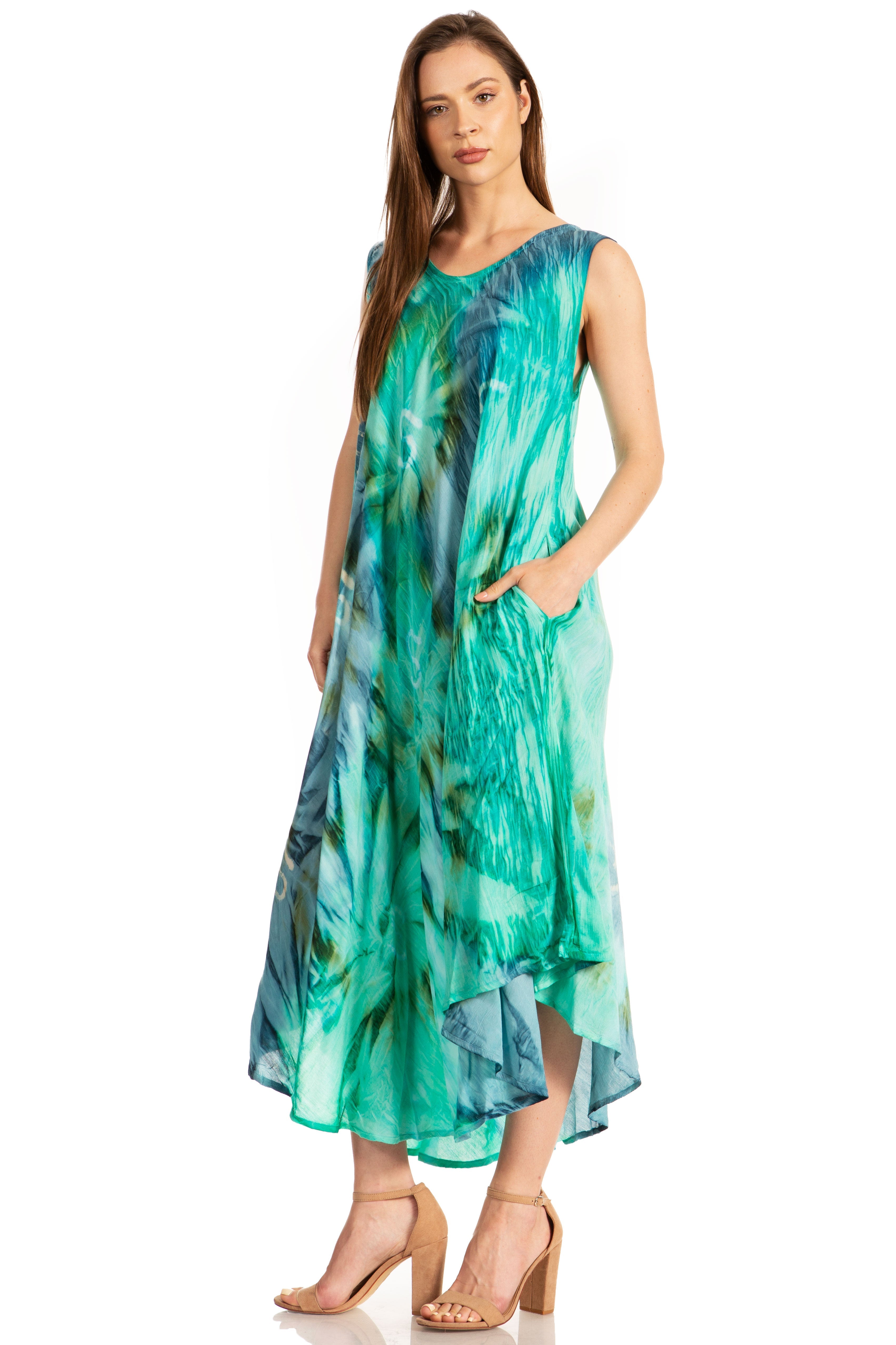 Woman wearing a sleeveless, green and blue patterned dress on a white background