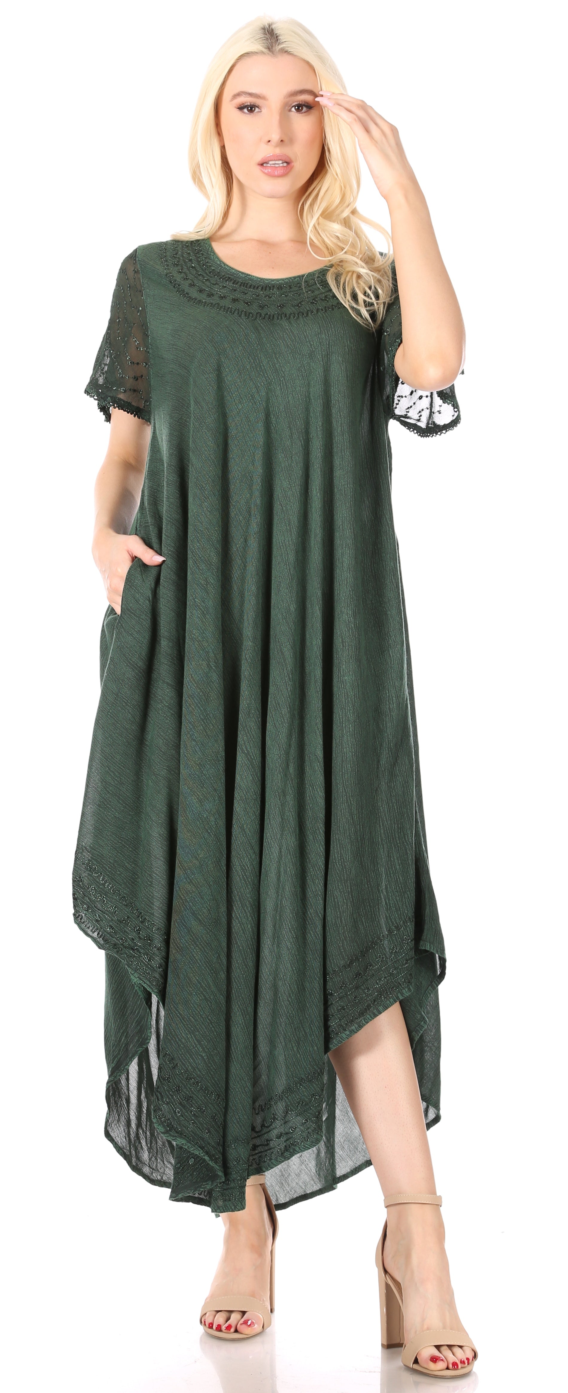 Woman wearing a green dress with sheer sleeves on a white background