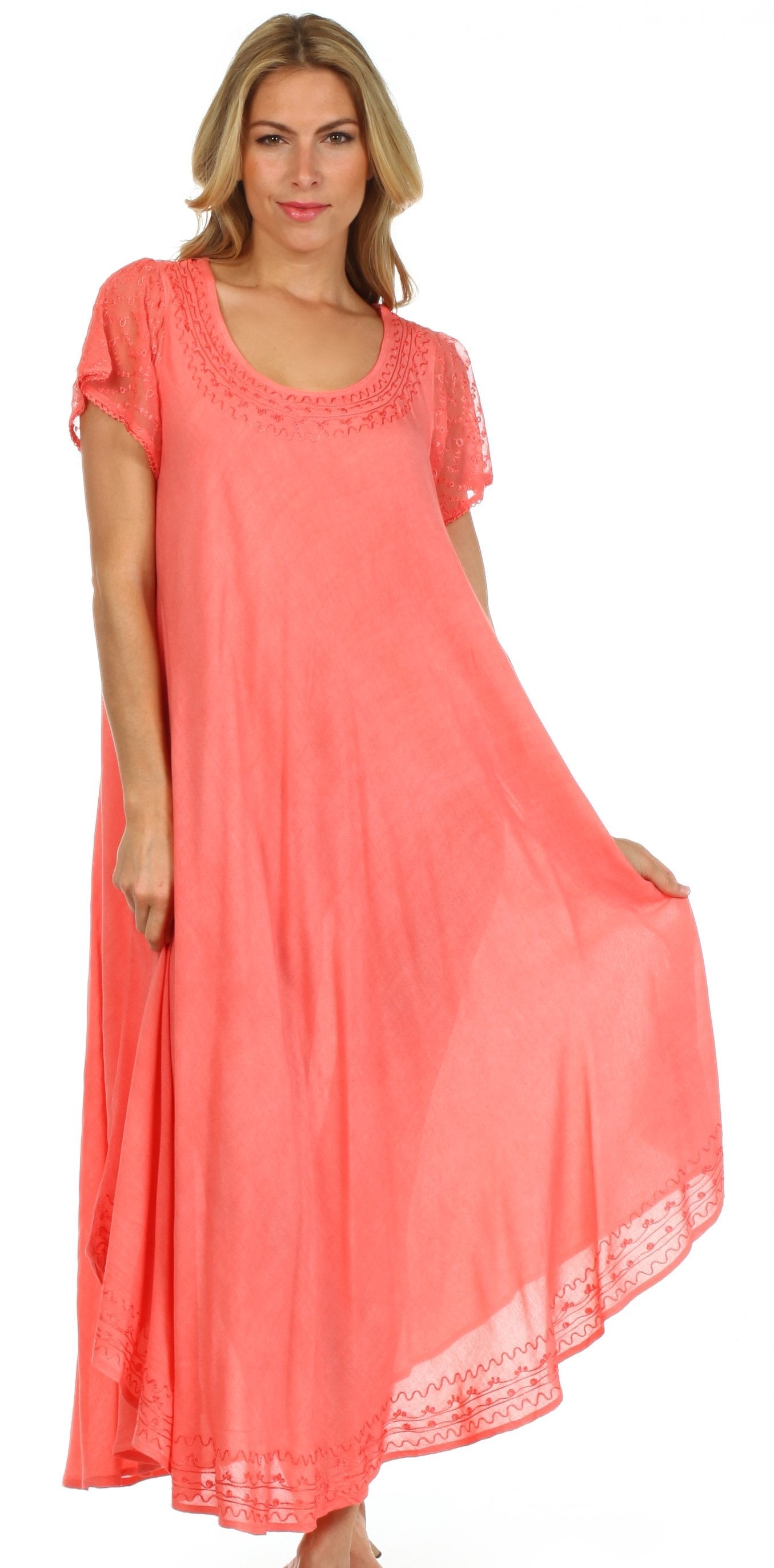 Woman wearing a coral dress with lace details on a white background