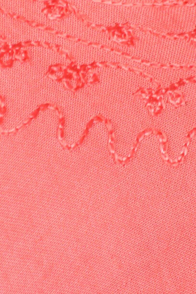 Close-up of pink fabric with floral embroidery