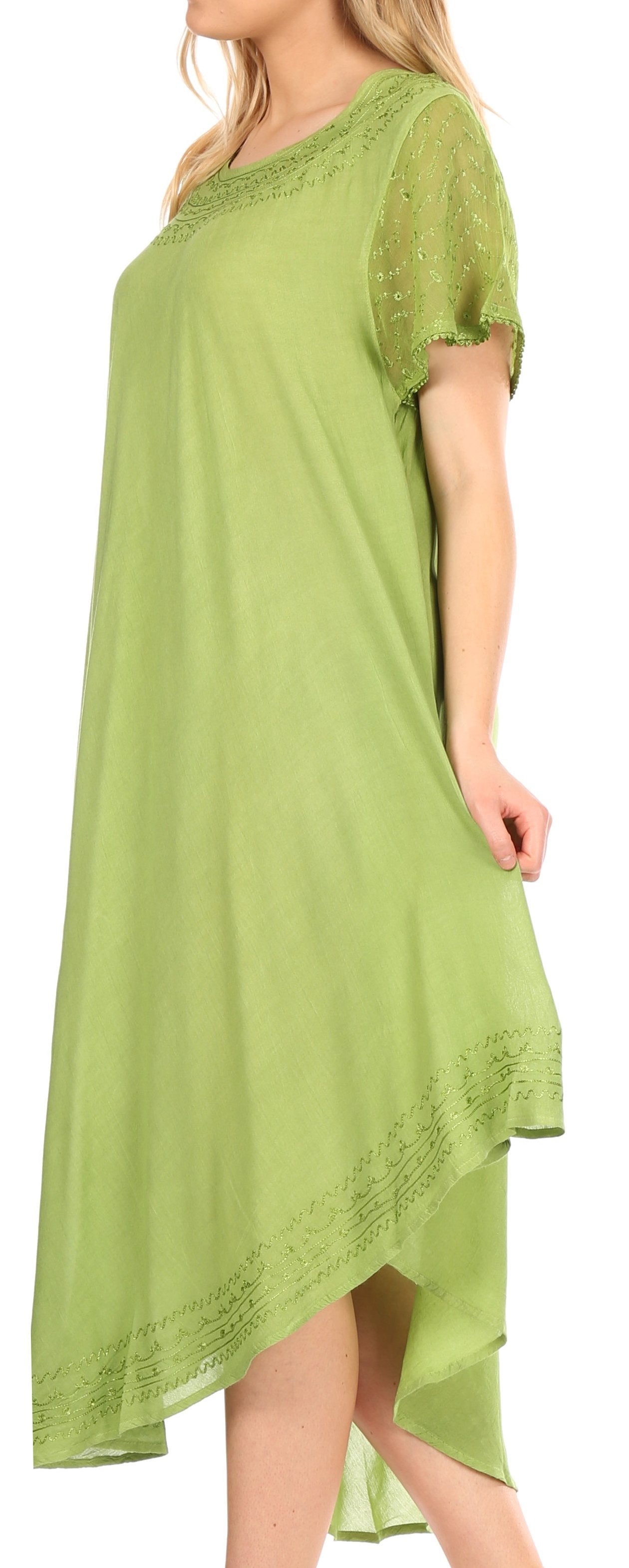 Woman wearing a green dress with lace details on a plain background