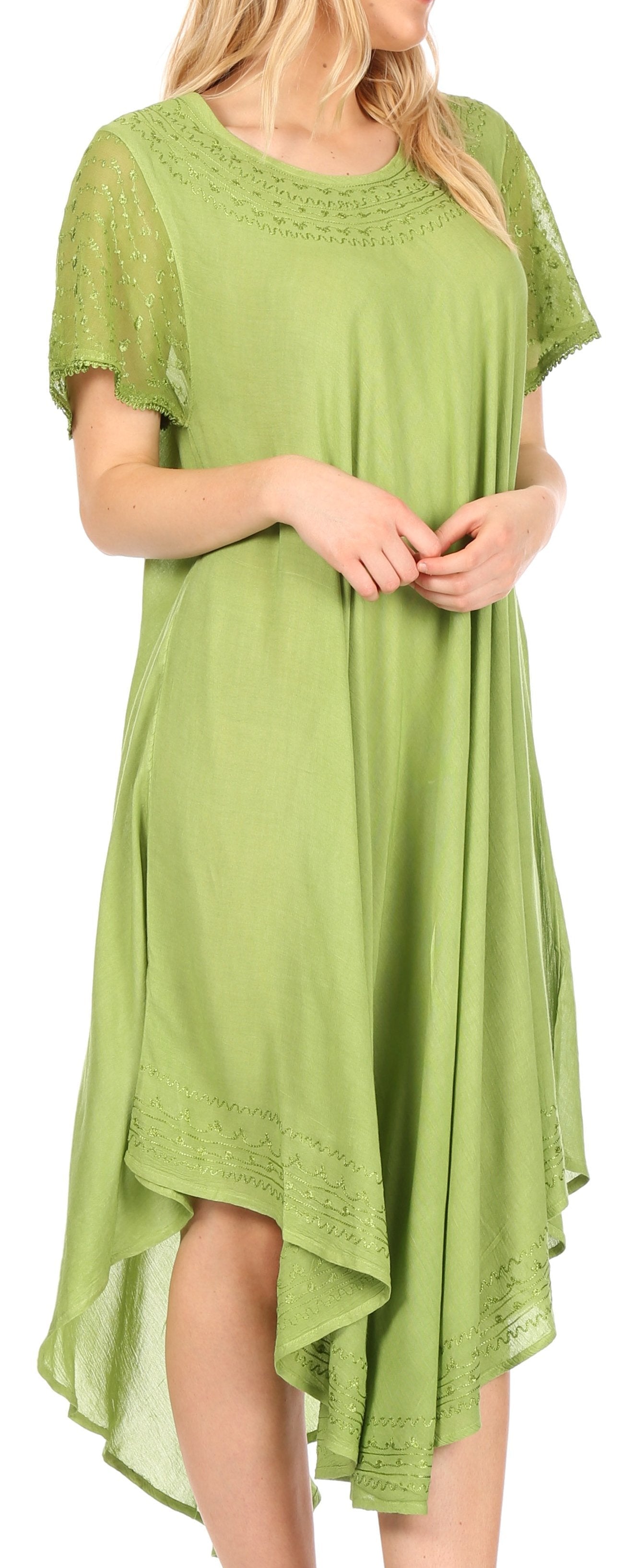 Woman wearing a green dress with lace details on a plain background