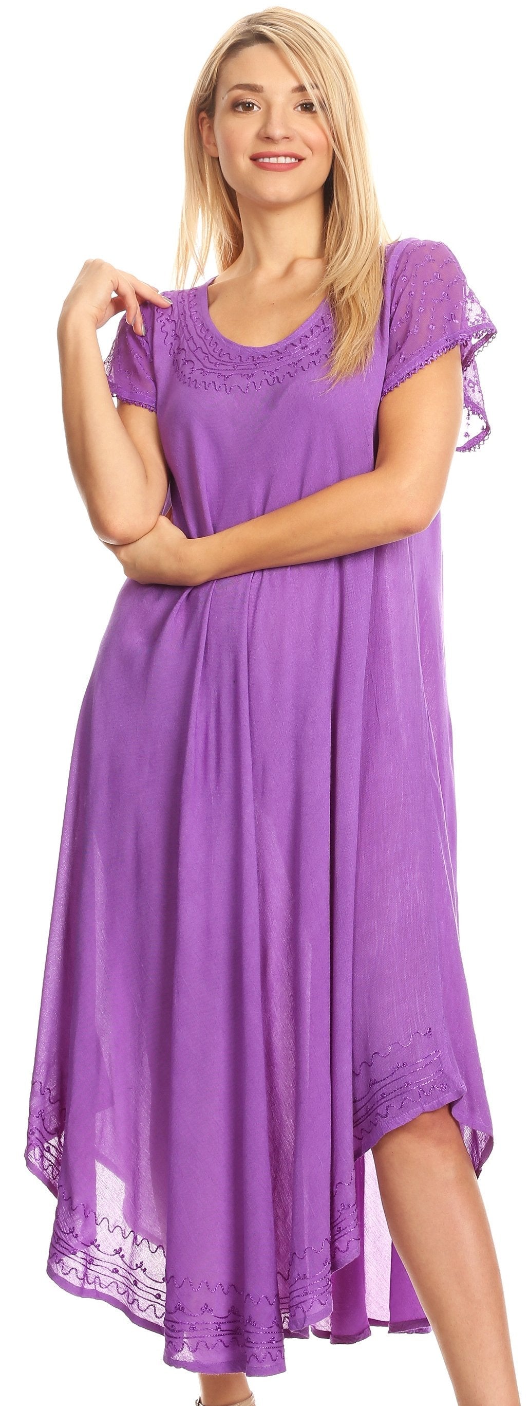 Woman wearing a purple dress with lace details, standing against a plain background.