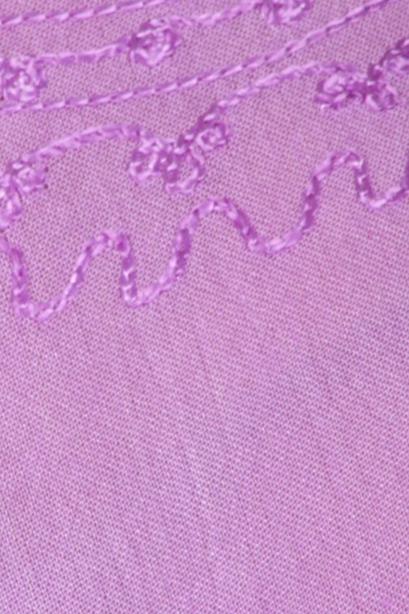 Close-up of a pink fabric with embroidered floral patterns