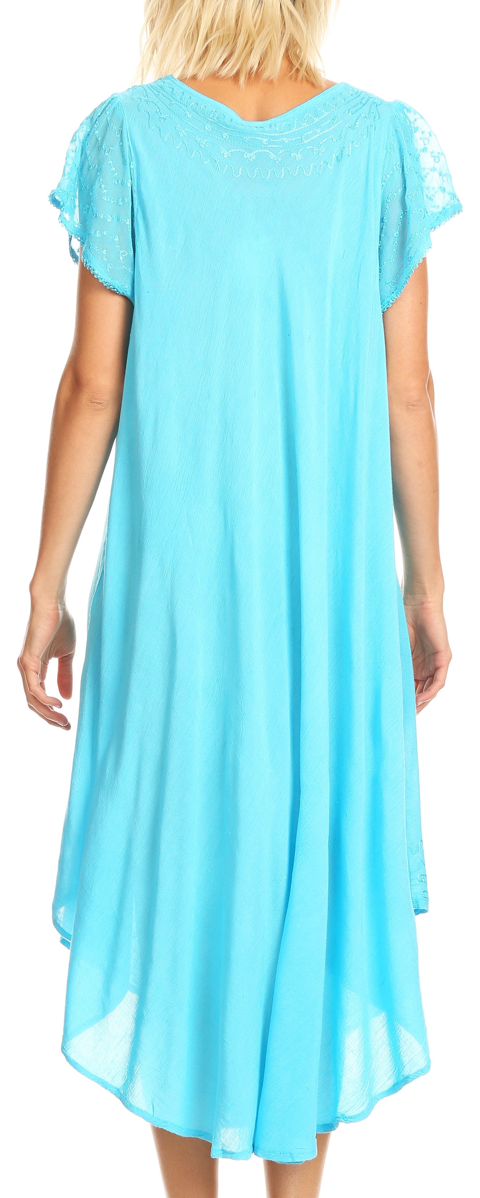 Woman wearing a light blue dress with lace sleeves against a neutral background