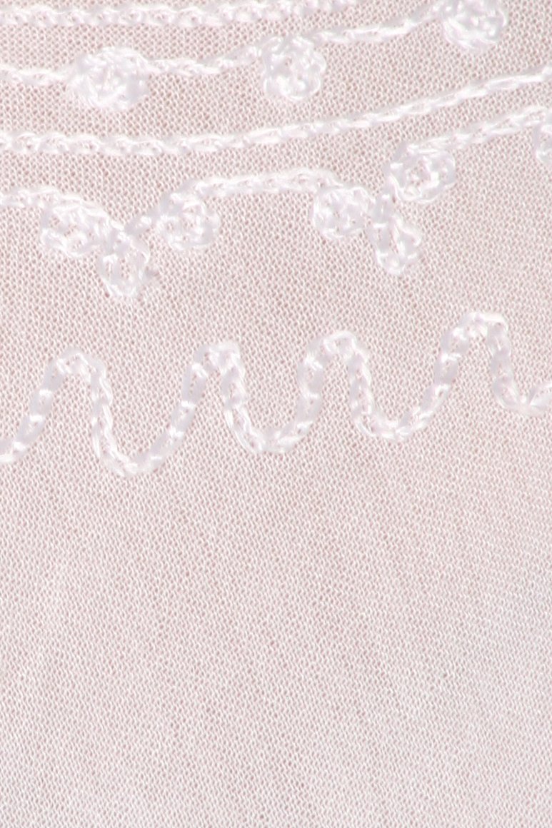 Close-up of textured fabric with a subtle pattern on a light pink background
