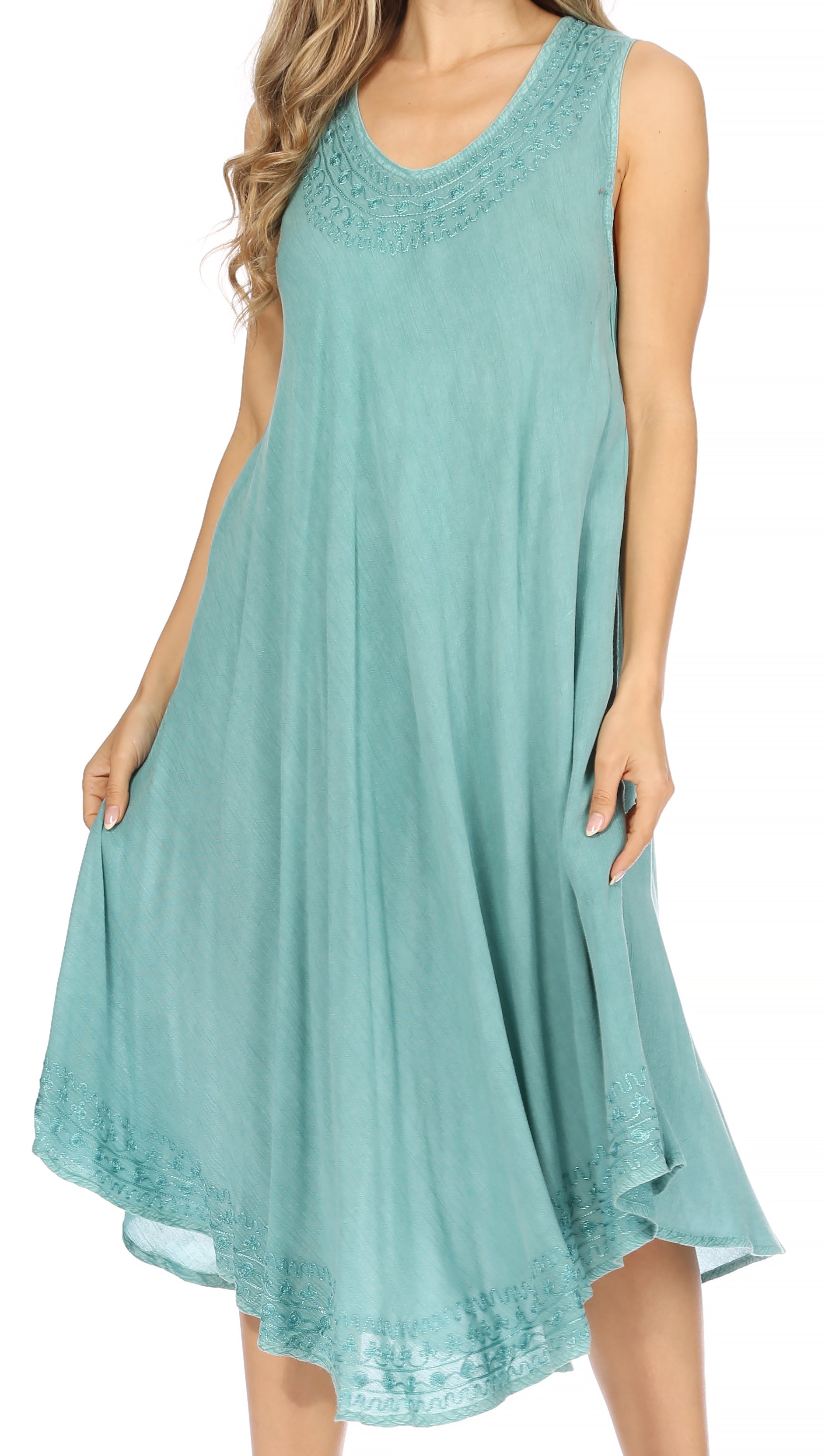 Woman wearing a sleeveless teal dress with lace details on a white background