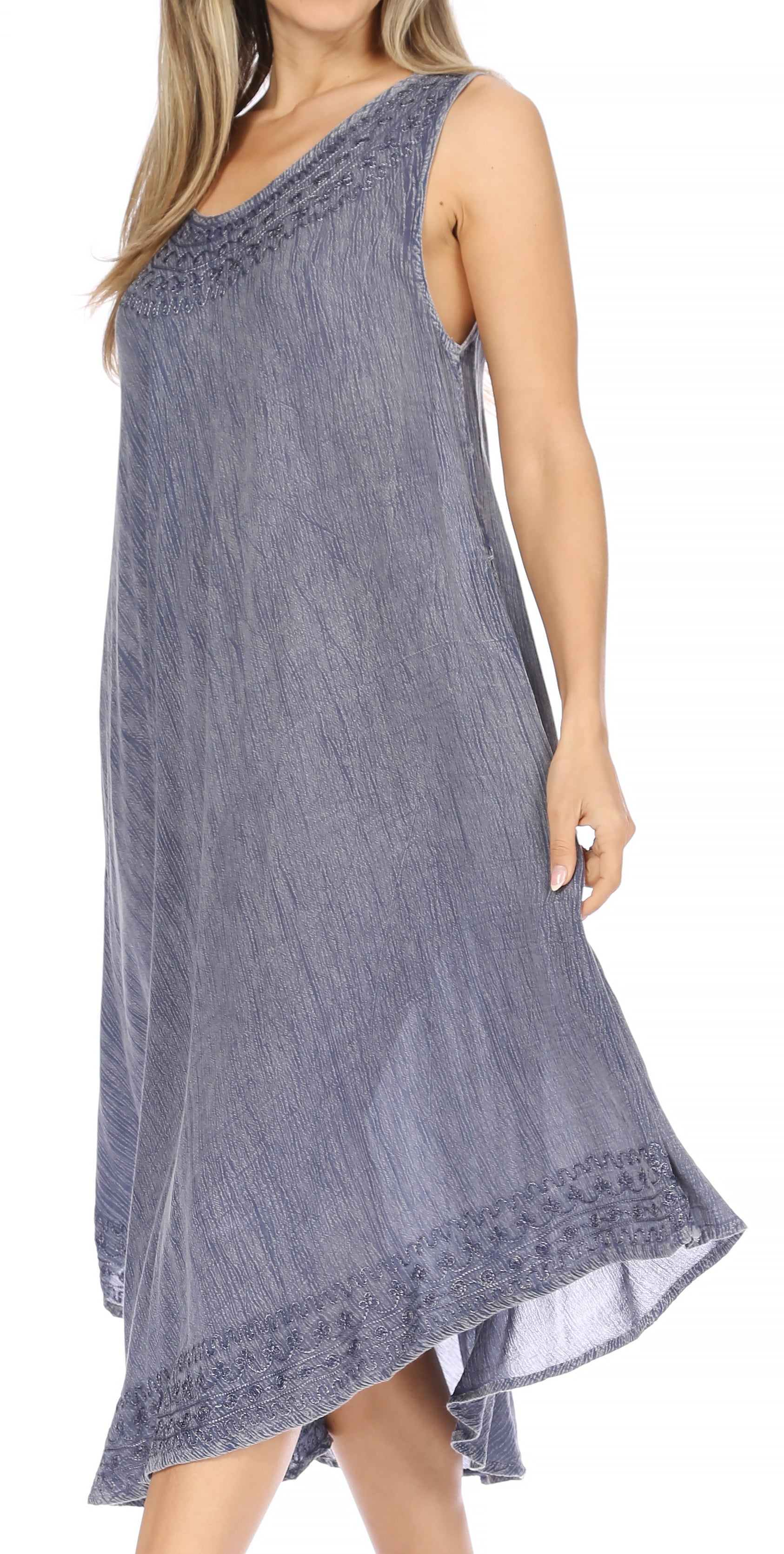 Woman wearing a sleeveless denim dress with lace details on a white background