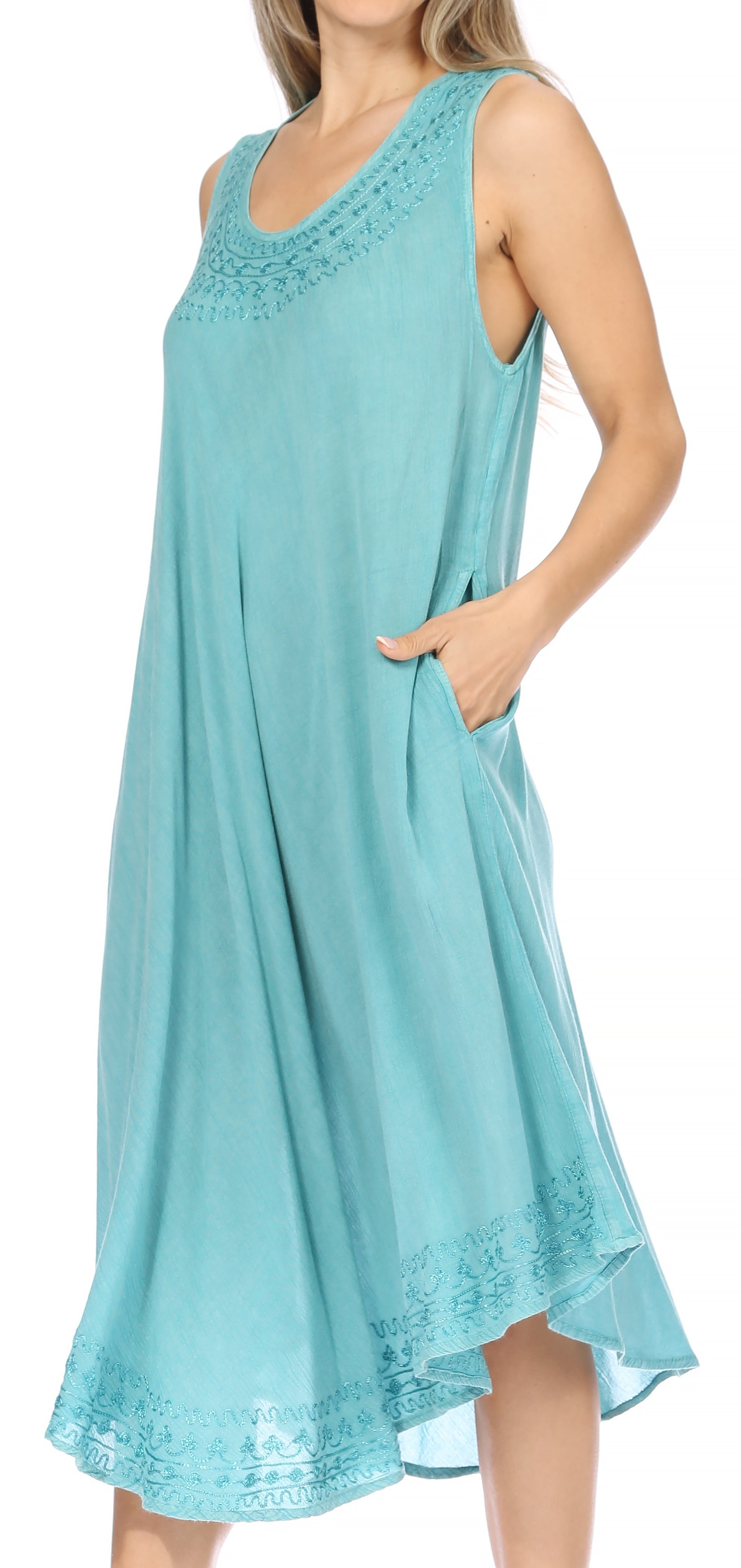 Woman wearing a light blue sleeveless dress with lace details on a white background