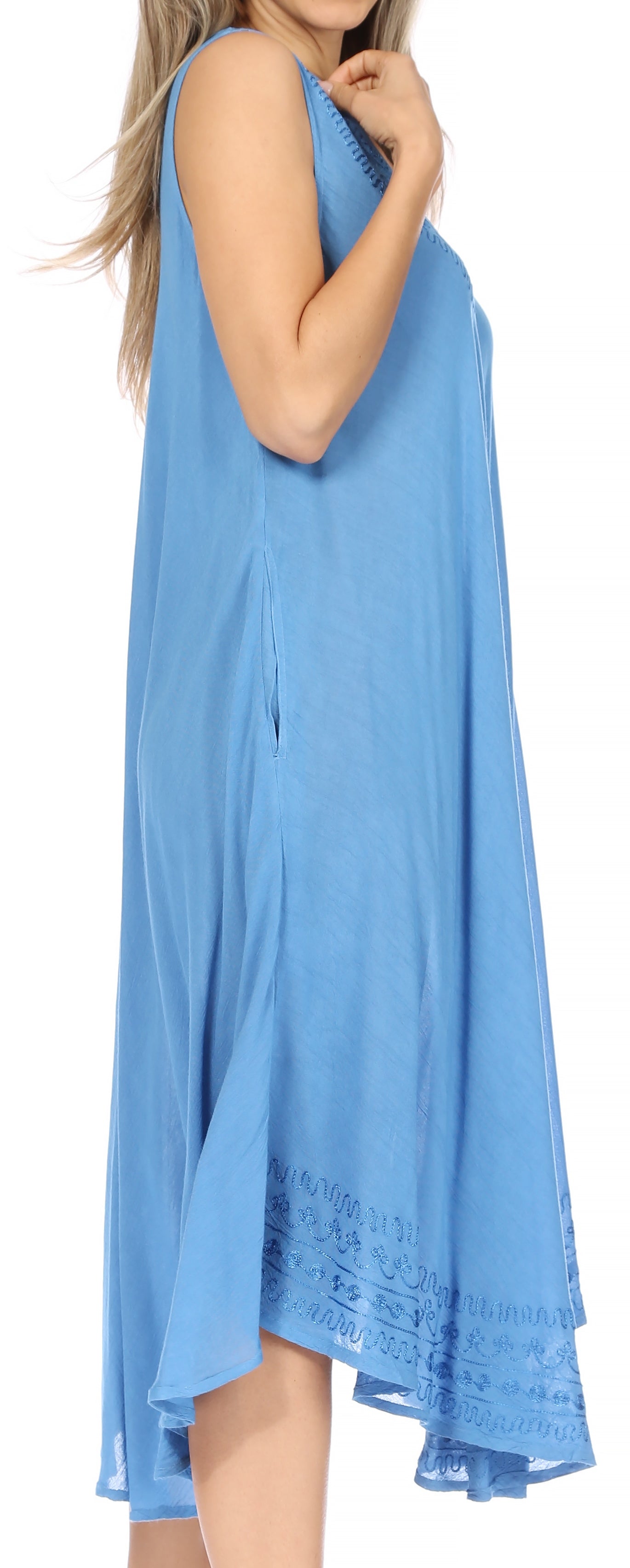Woman wearing a blue sleeveless dress with lace trim on a white background