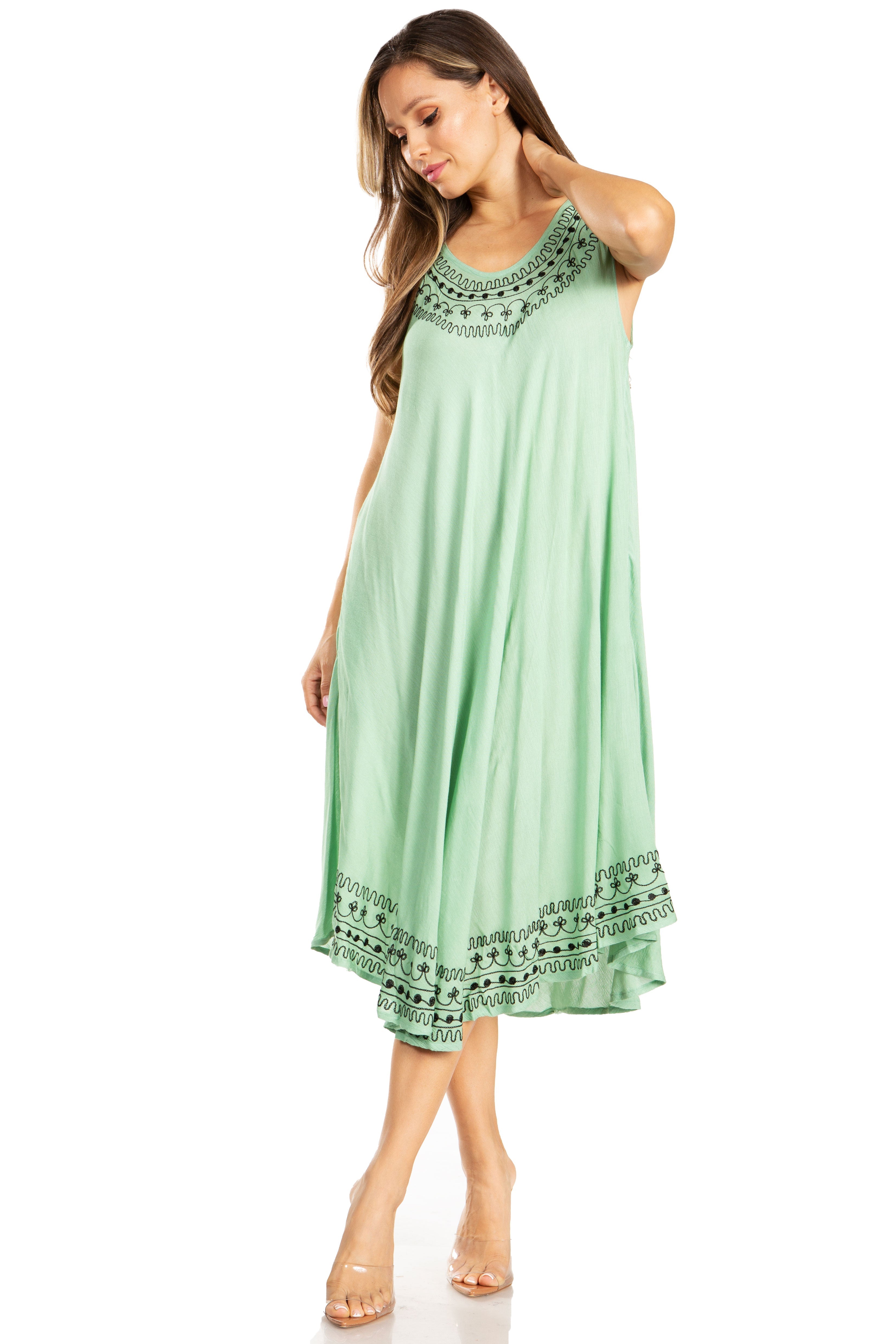 Woman wearing a green dress with intricate patterns on a white background