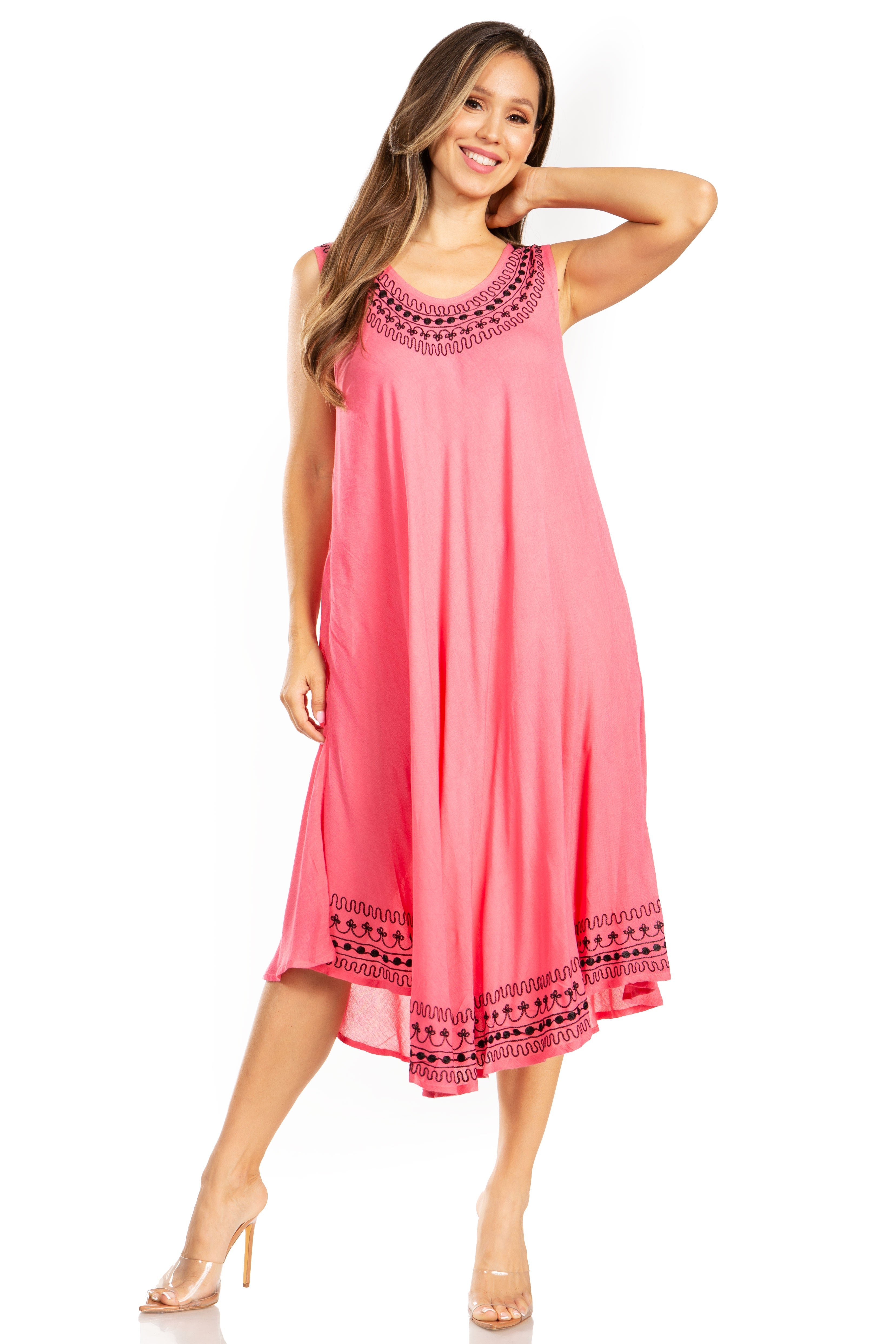 Woman wearing a pink dress with black embroidery on a white background