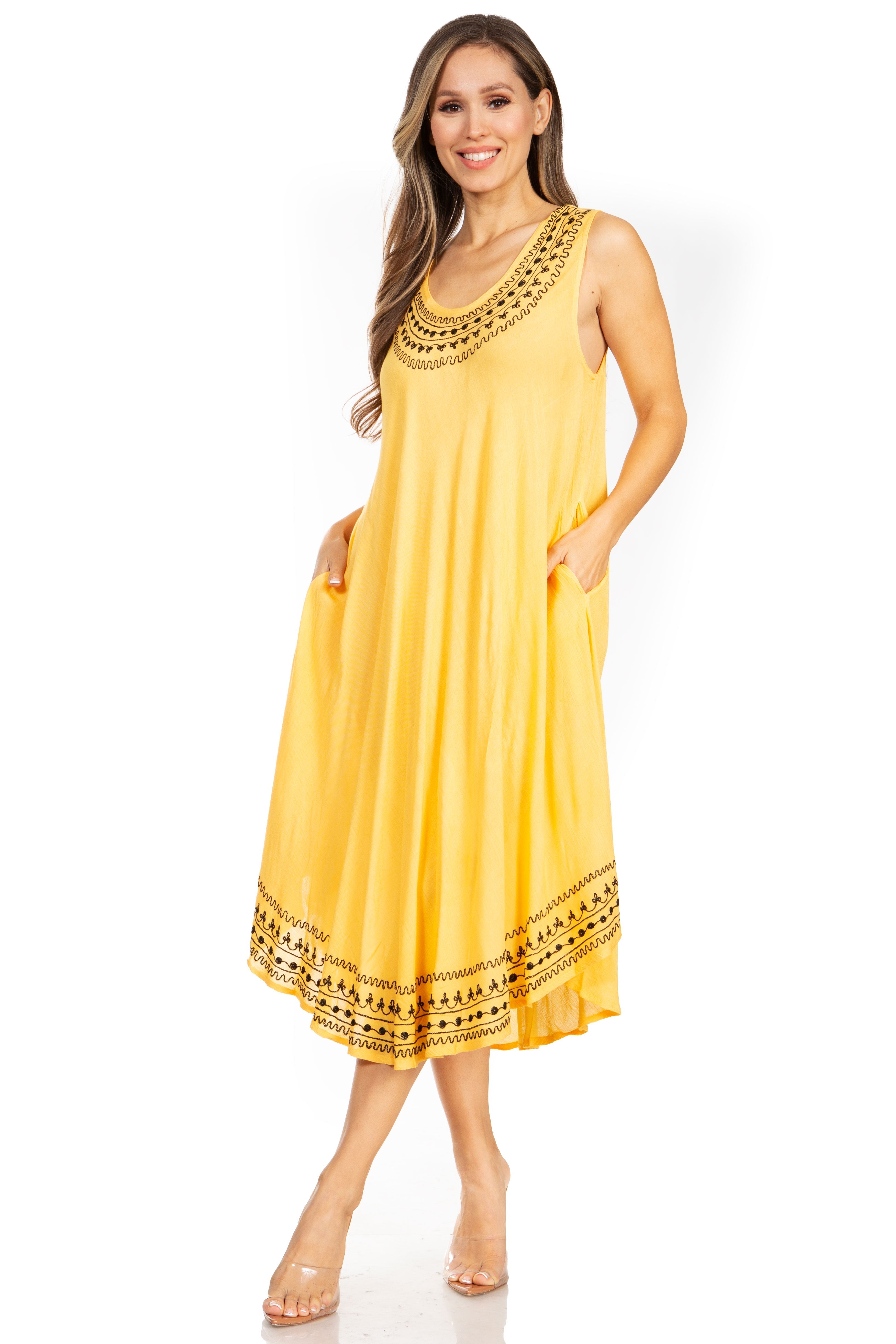 Woman wearing a yellow dress with black embroidery on a white background