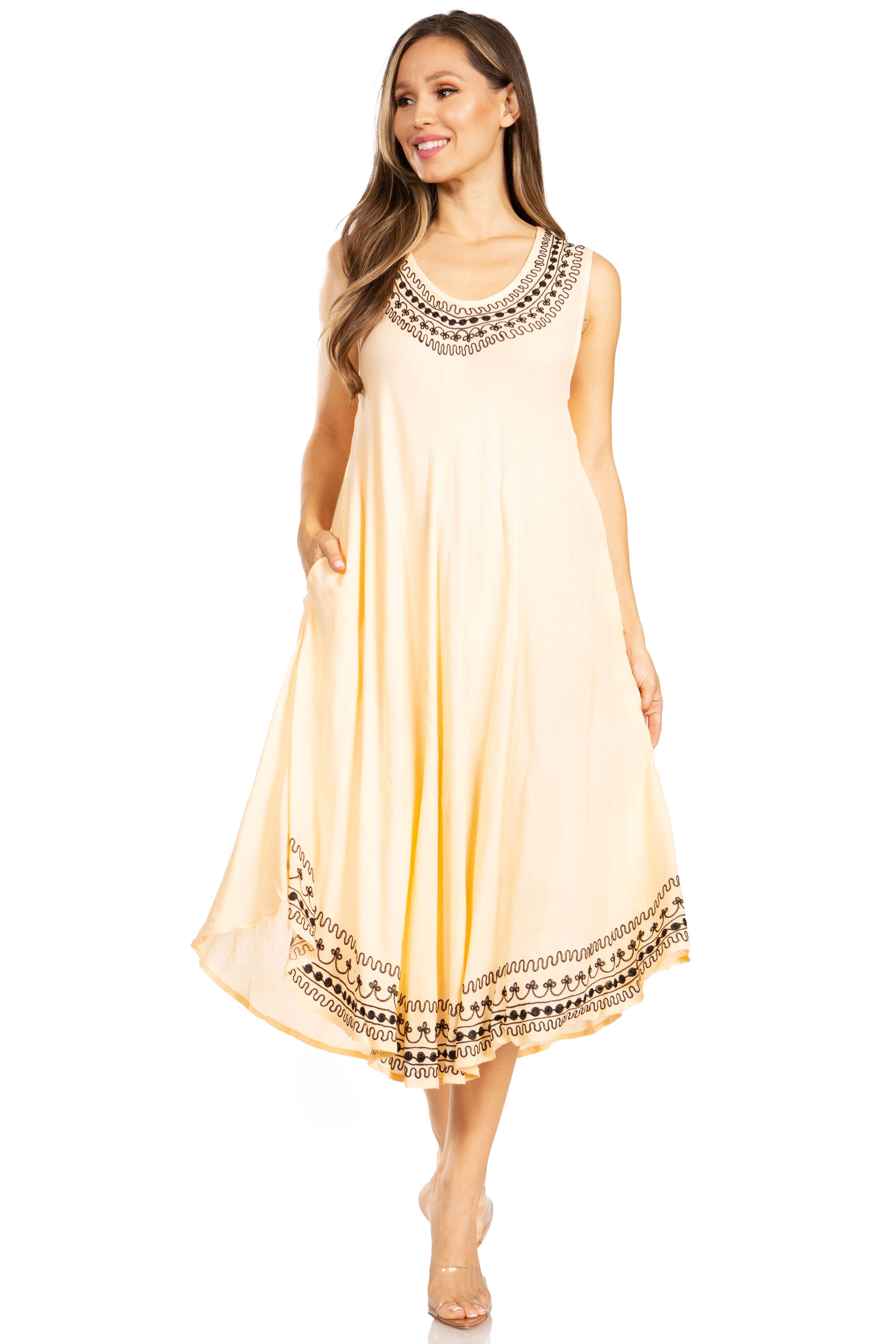 Woman wearing a beige sleeveless dress with black embroidery on a white background