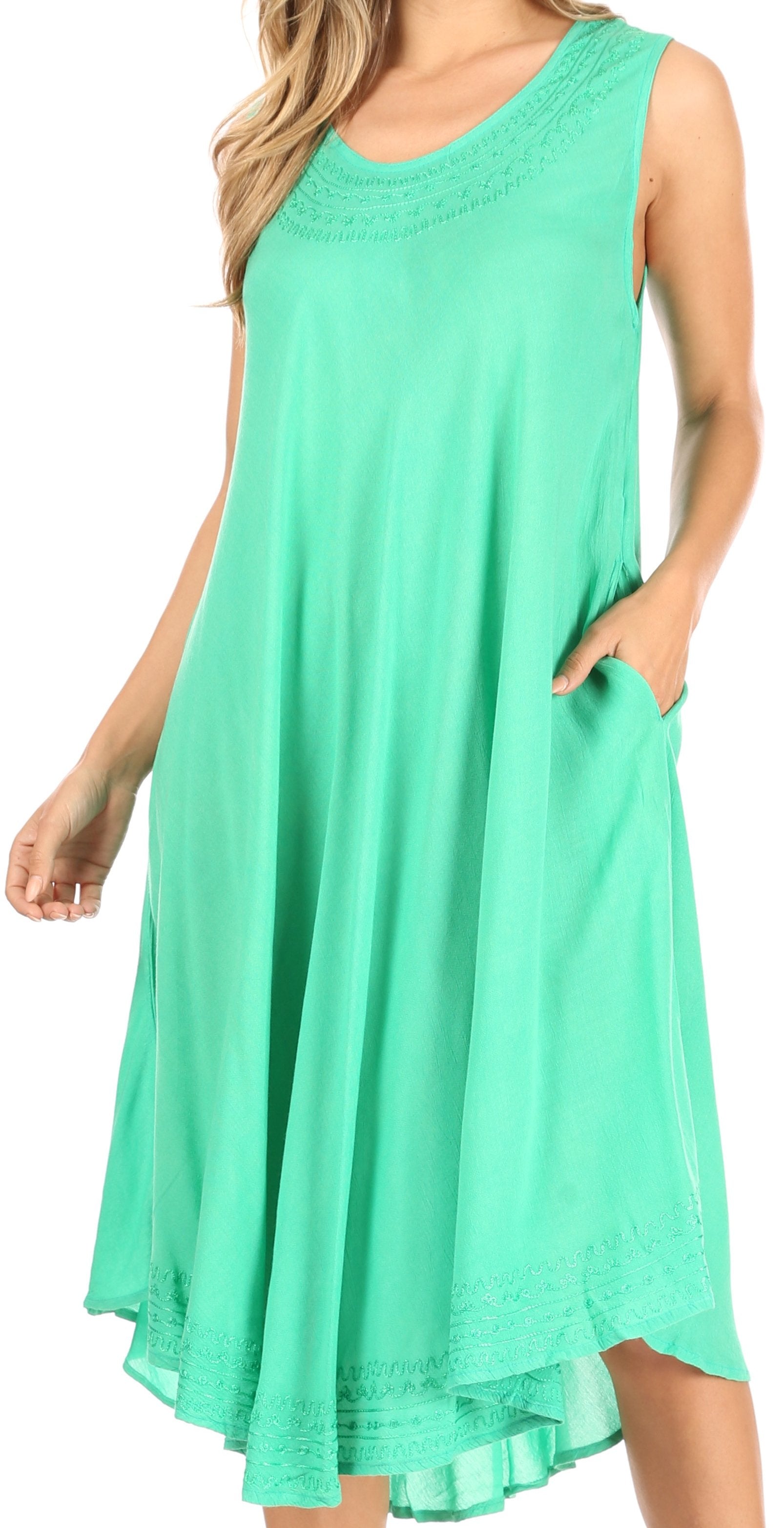 Woman wearing a mint green sleeveless dress with pockets on a white background