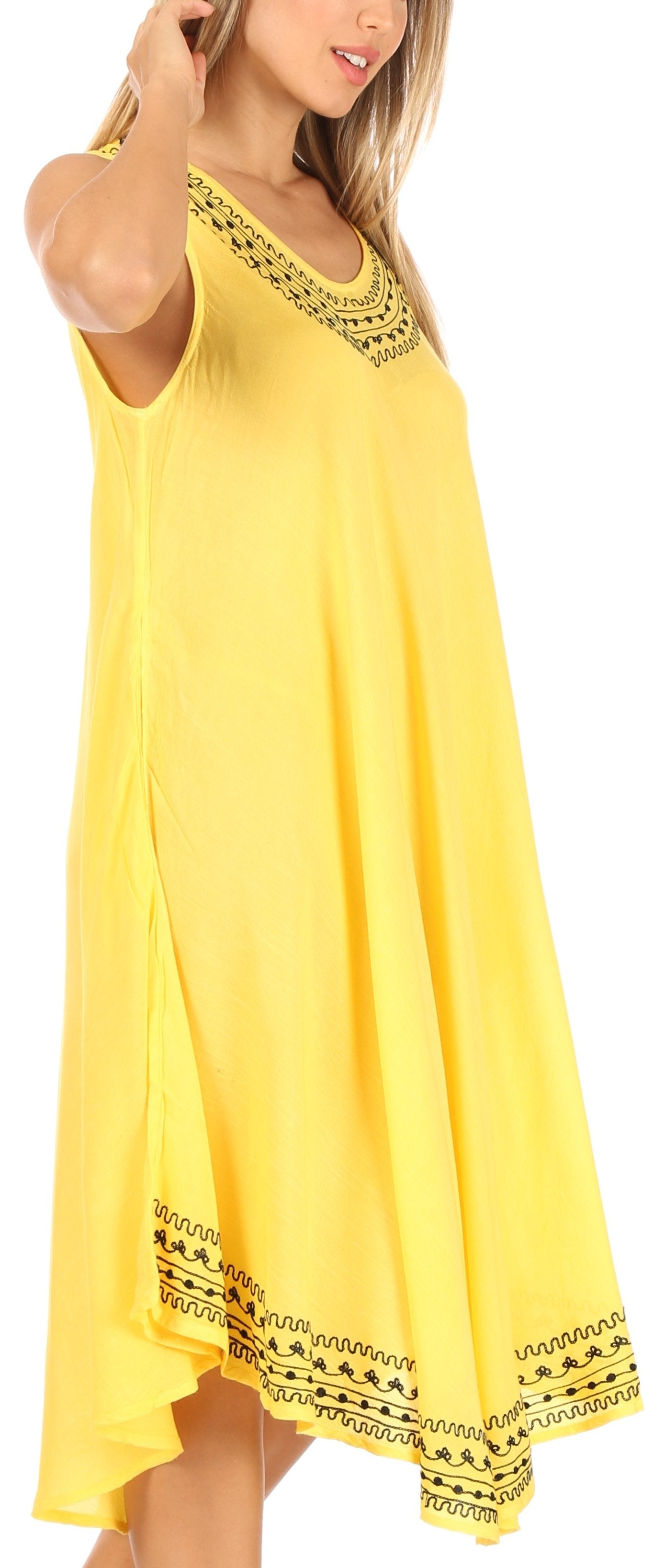 Woman wearing a yellow dress with black embroidery on a white background