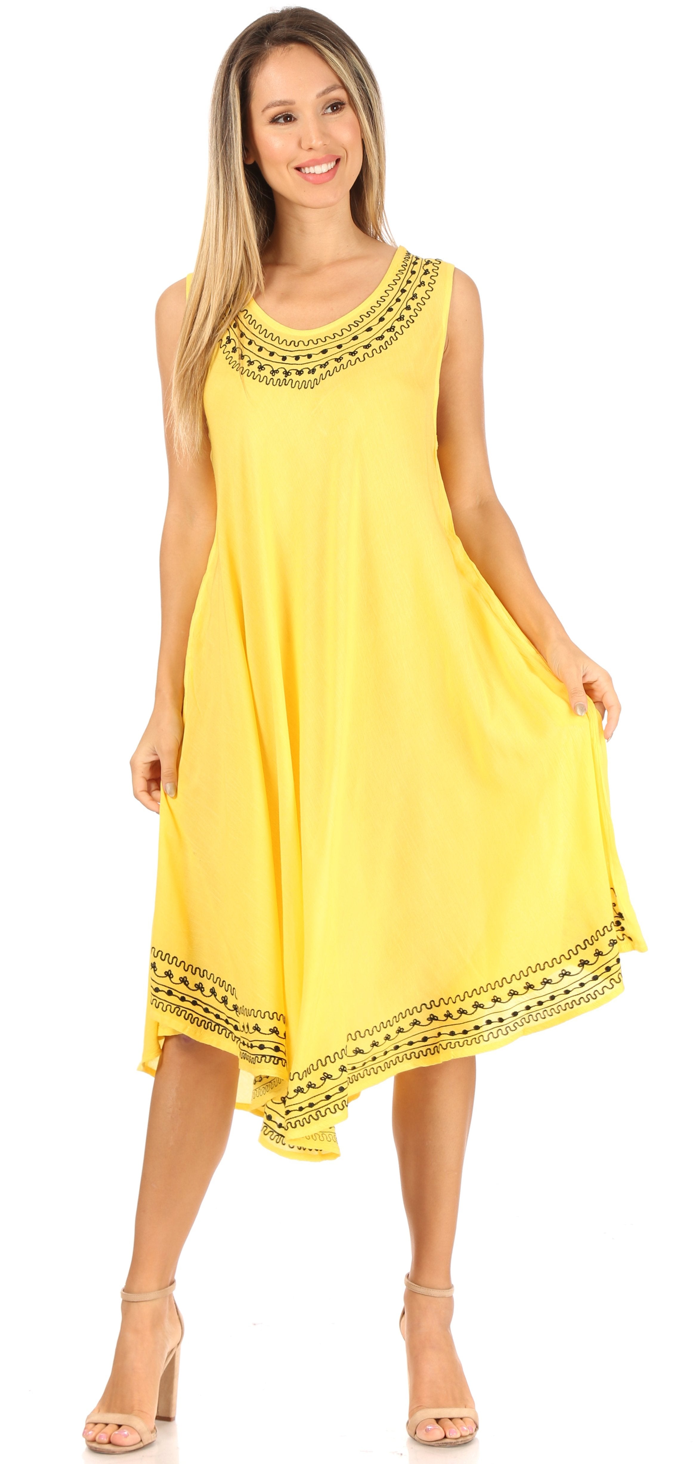 Woman wearing a yellow dress with black lace details on a white background