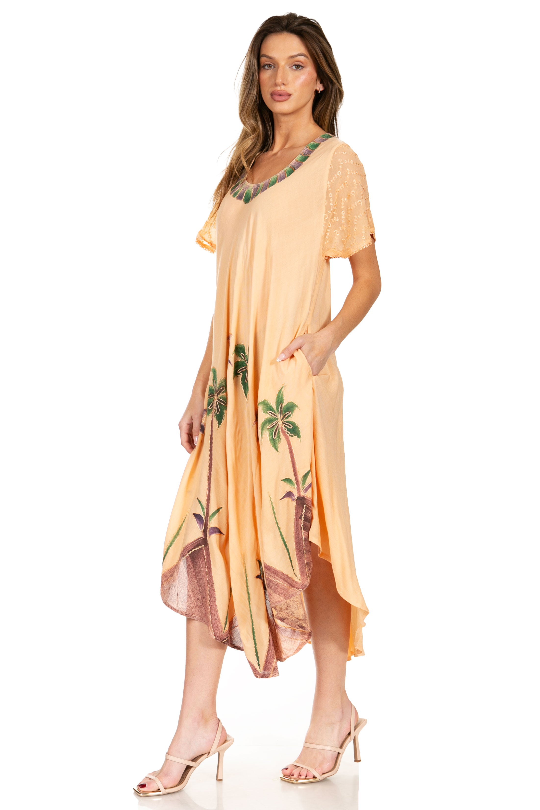 Woman wearing a peach-colored dress with floral patterns on a white background