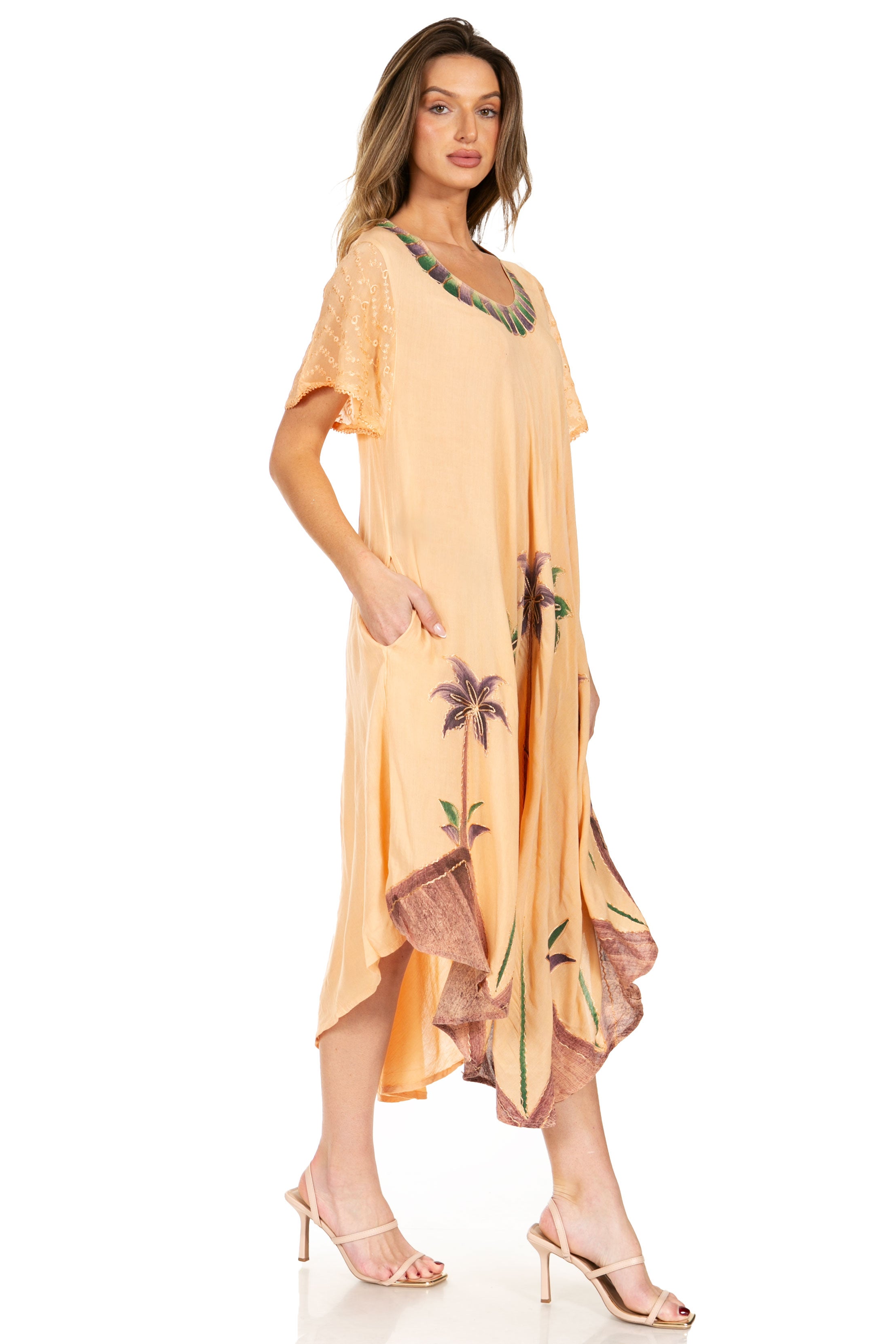 Woman wearing a peach-colored dress with floral patterns on a white background