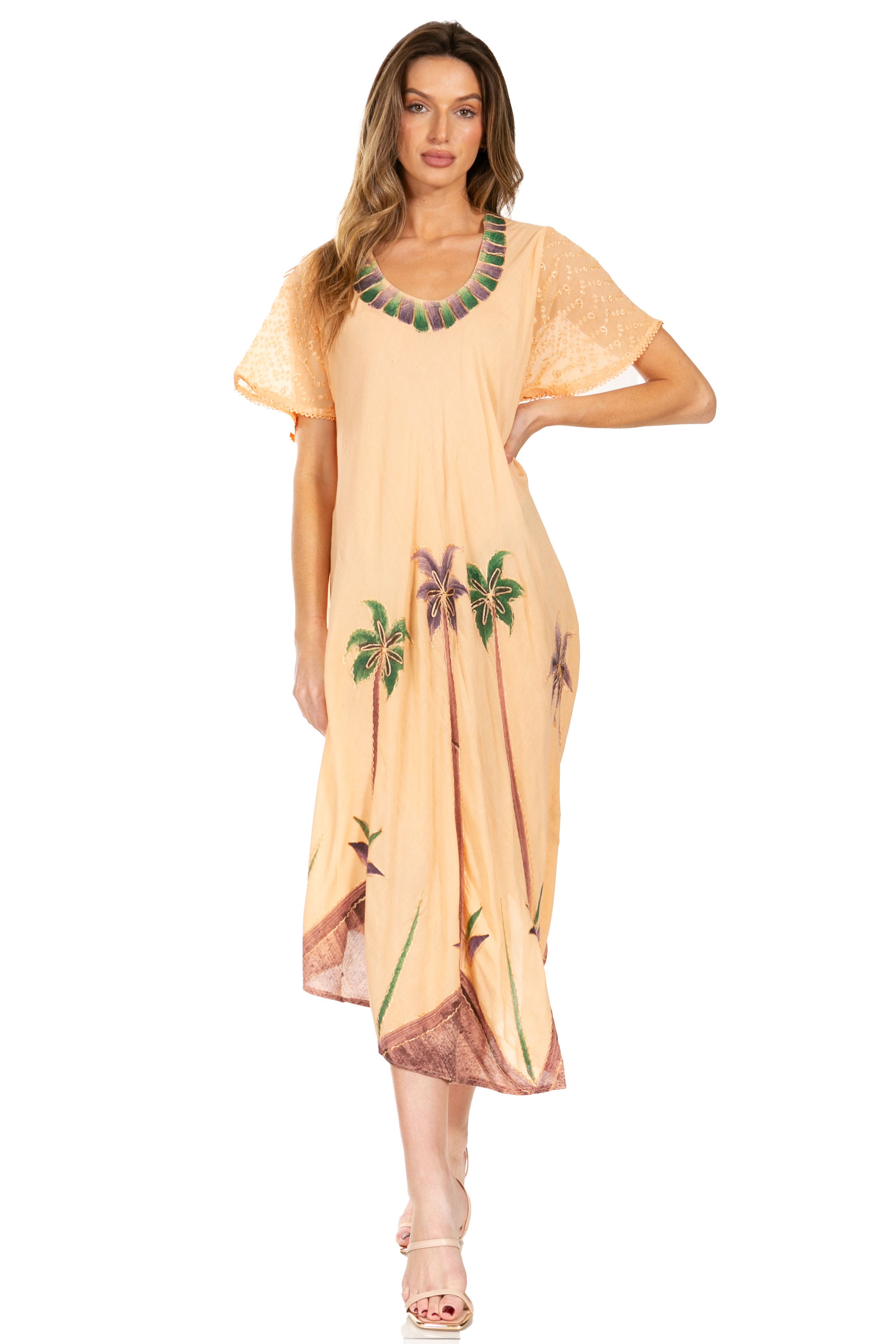 Woman wearing a peach-colored dress with floral embroidery on a white background