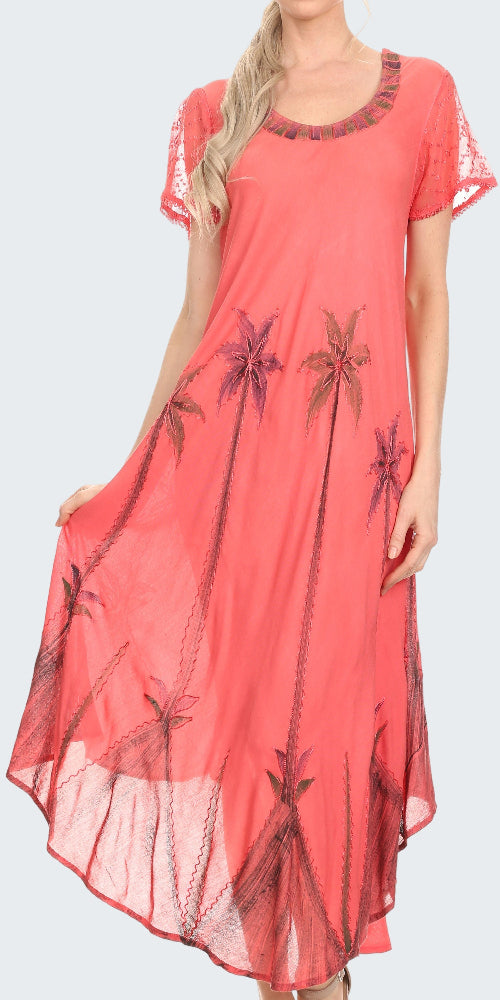 Coral dress with palm tree pattern worn by a model on a white background