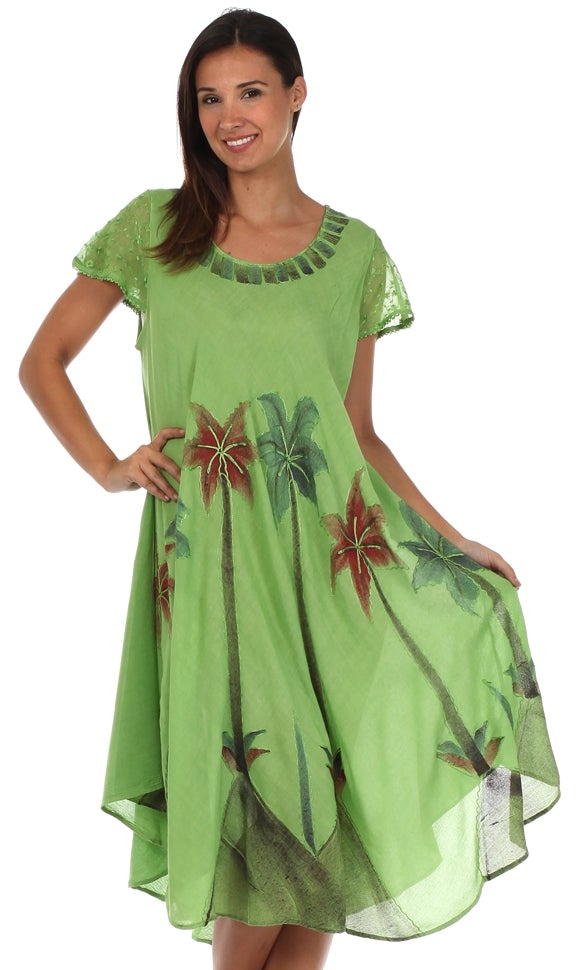 Woman wearing a green dress with floral patterns on a white background