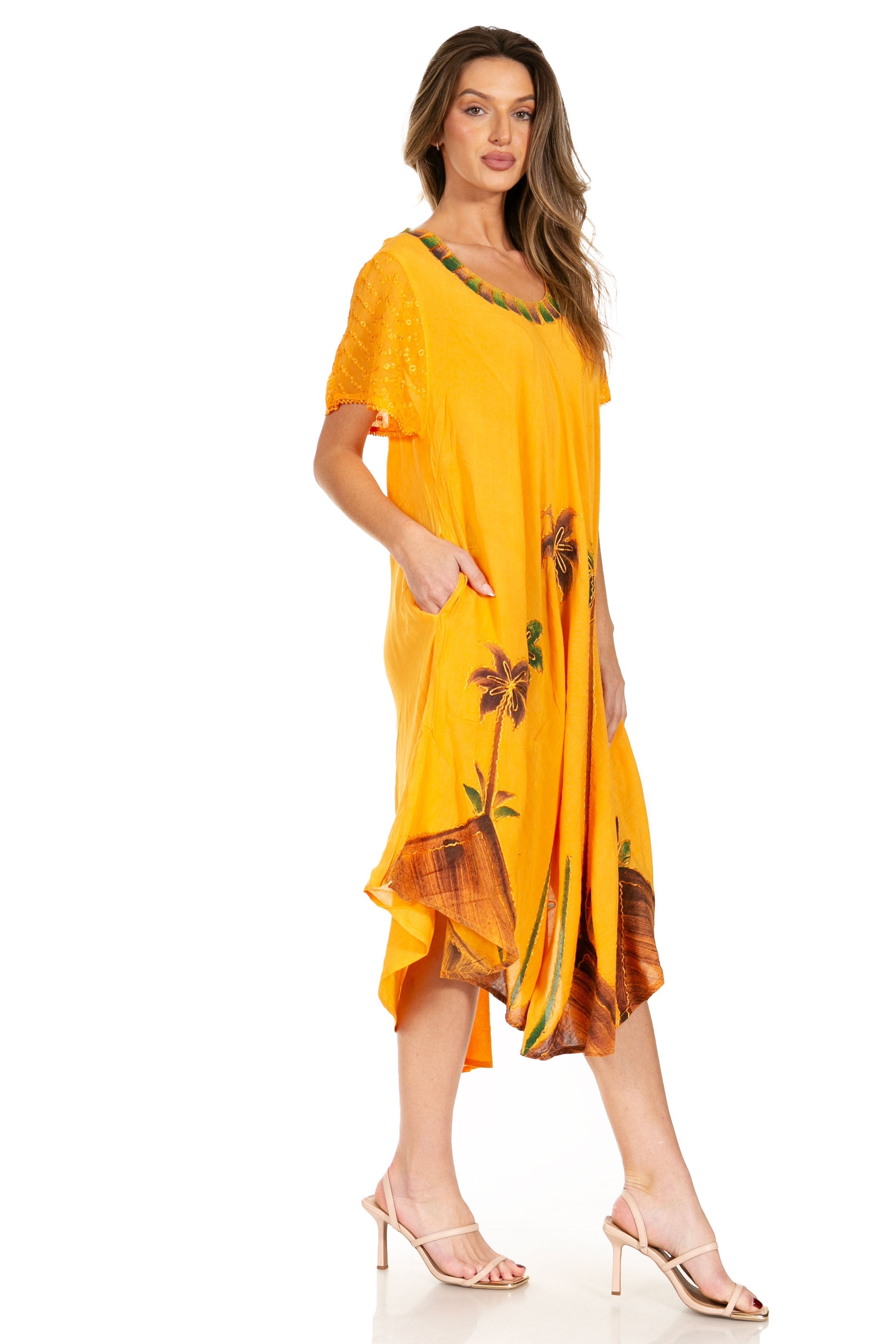 Woman wearing a yellow dress with floral patterns on a white background