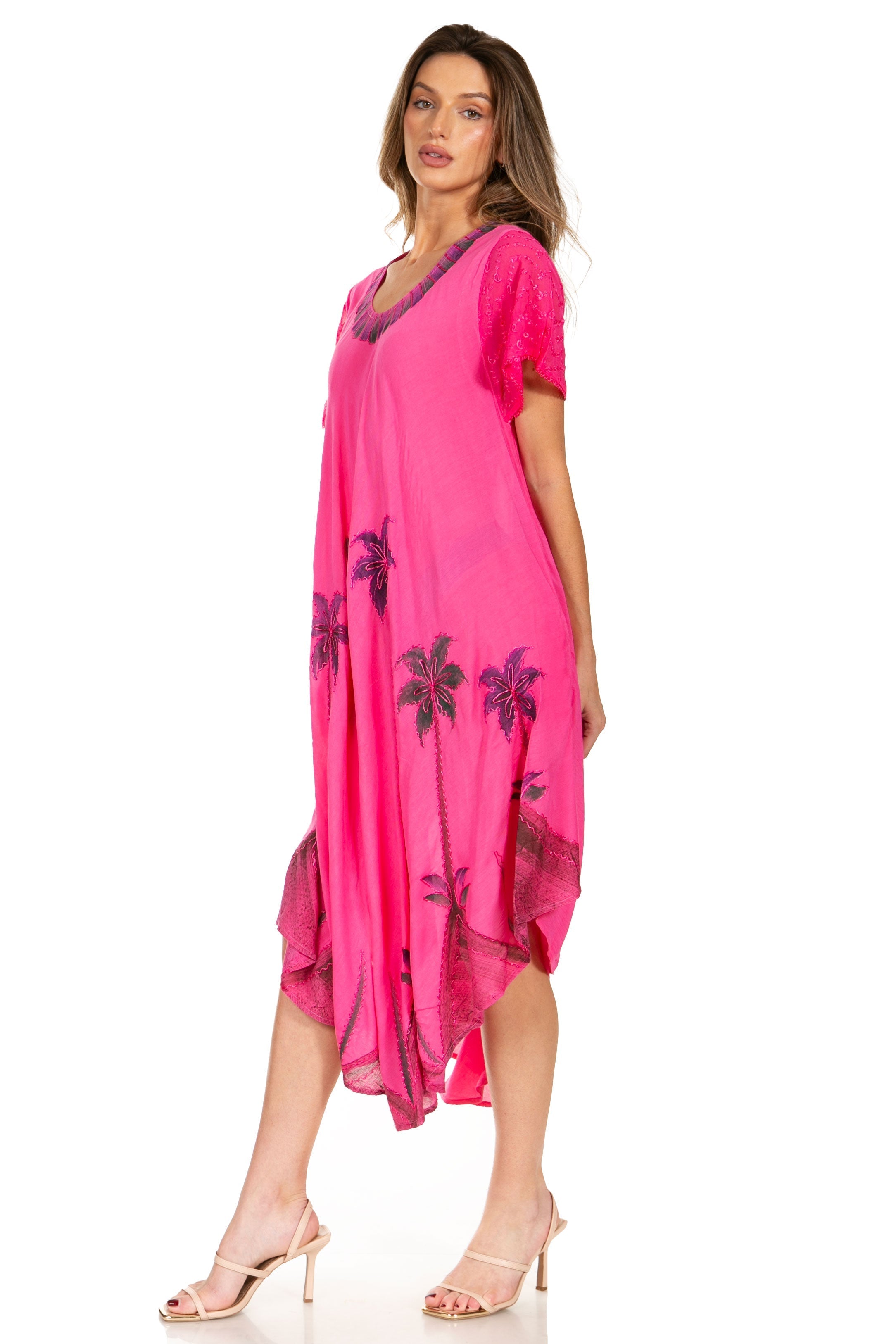 Woman wearing a pink dress with floral patterns on a white background
