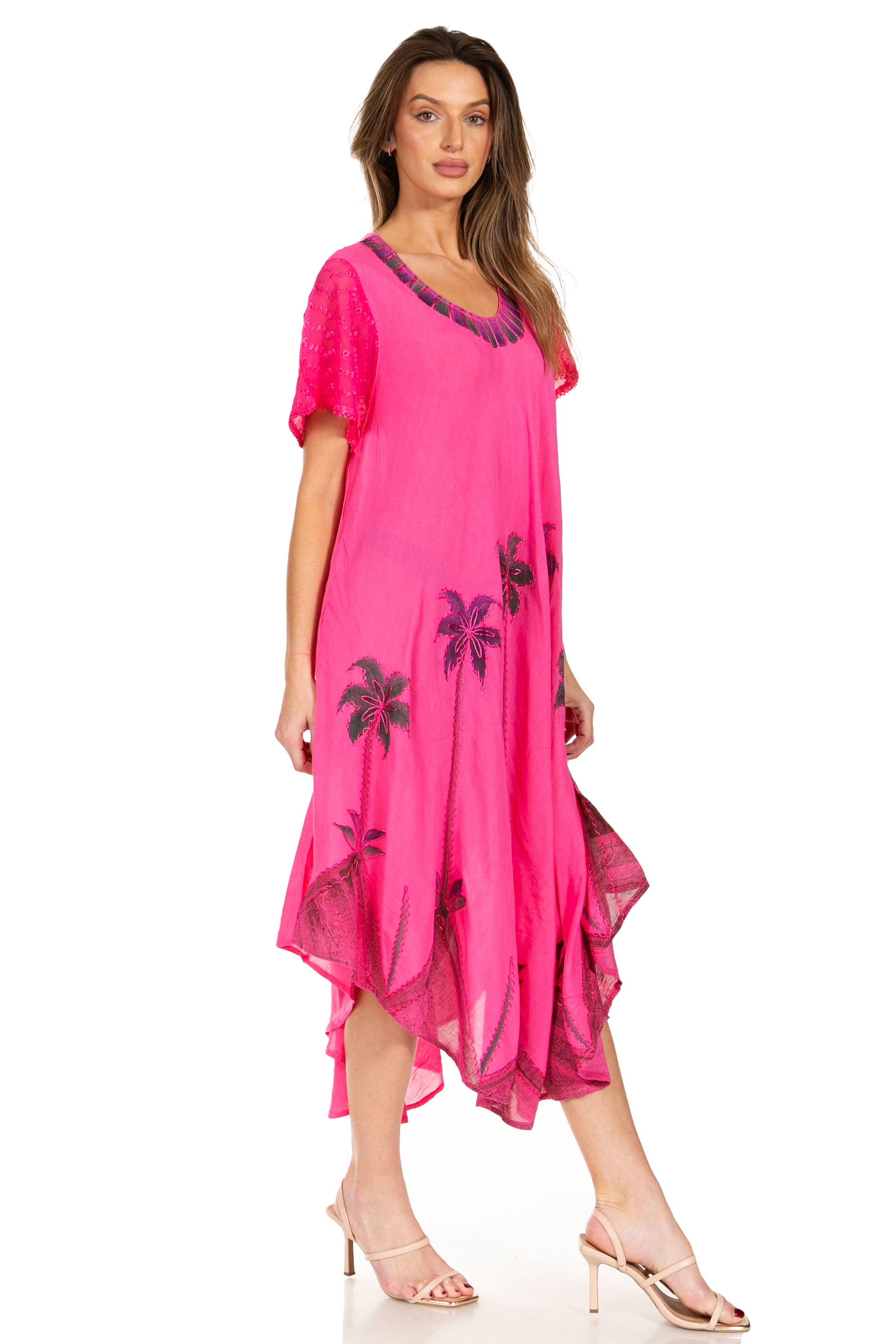 Woman wearing a pink dress with black floral patterns on a white background