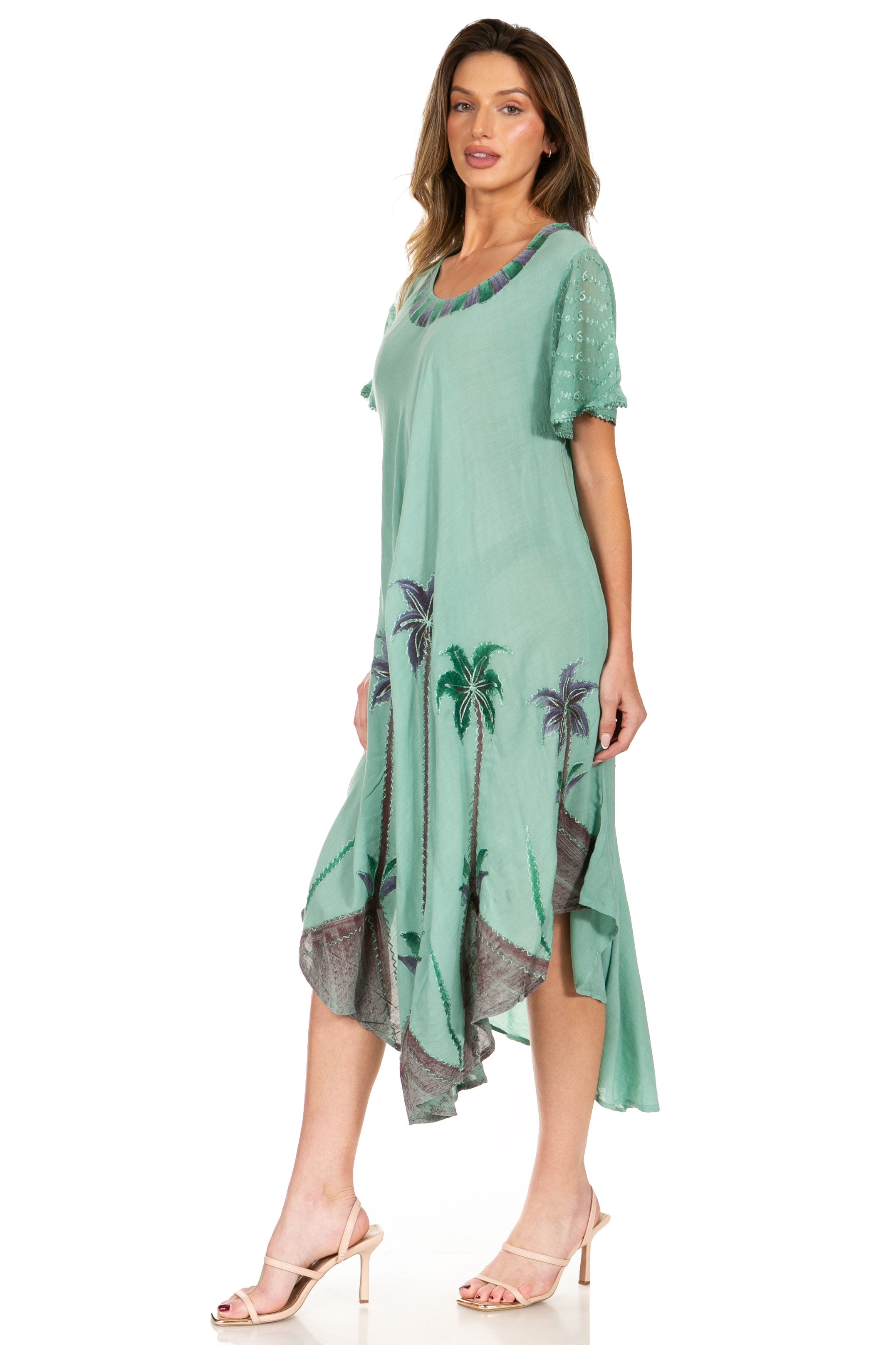Woman wearing a green dress with palm tree pattern on a white background