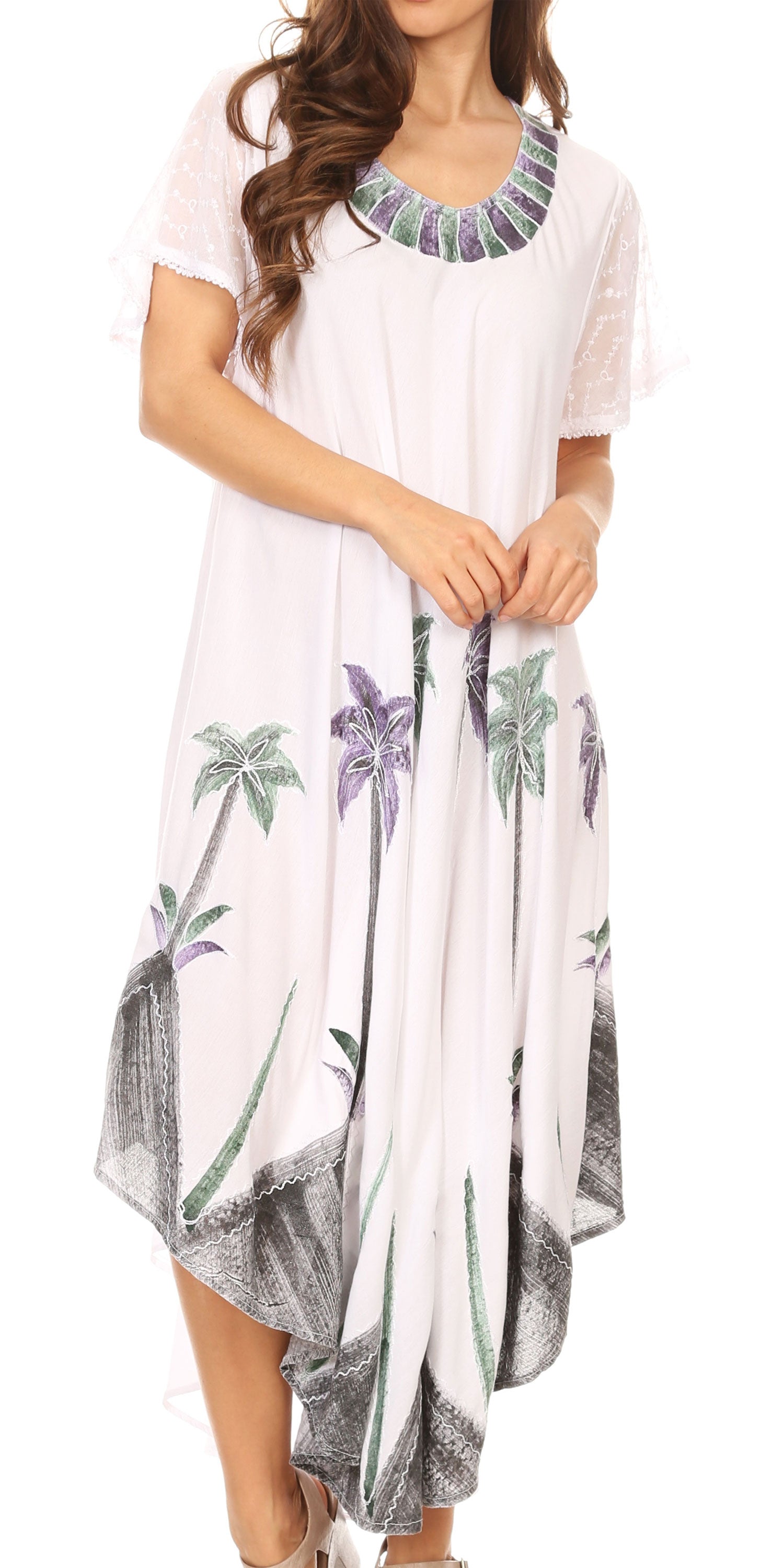 Woman wearing a white dress with floral and palm tree patterns on a plain background