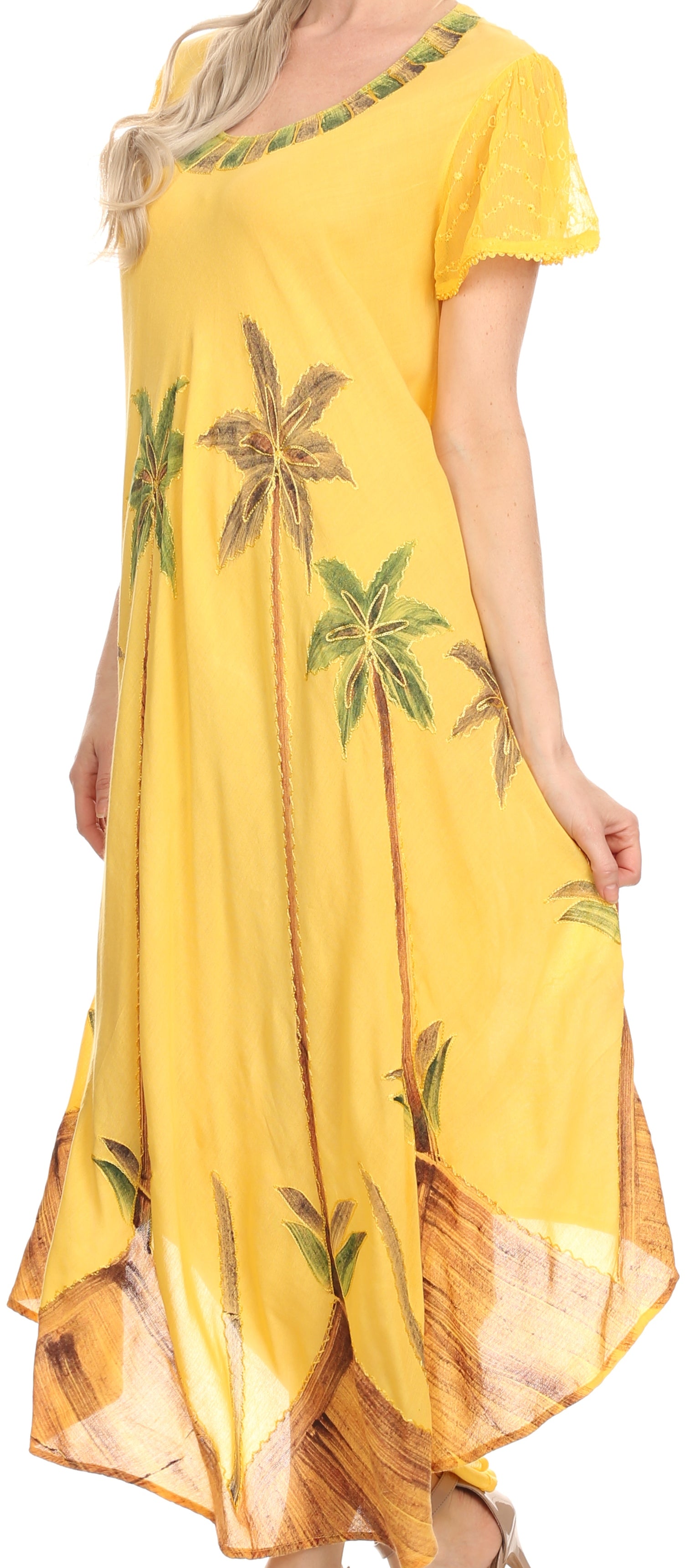 Woman wearing a yellow dress with tropical leaf patterns