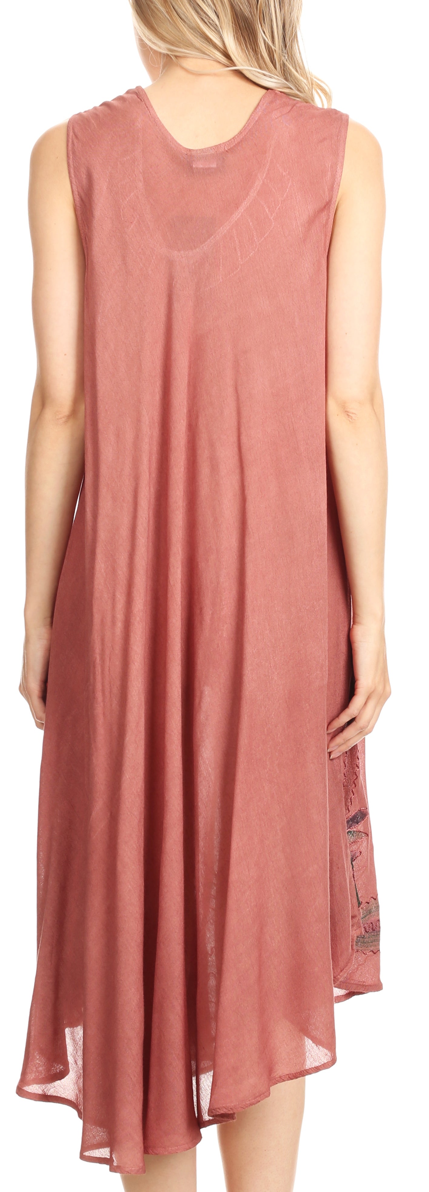 Woman wearing a sleeveless, long pink dress with a subtle pattern on a plain background