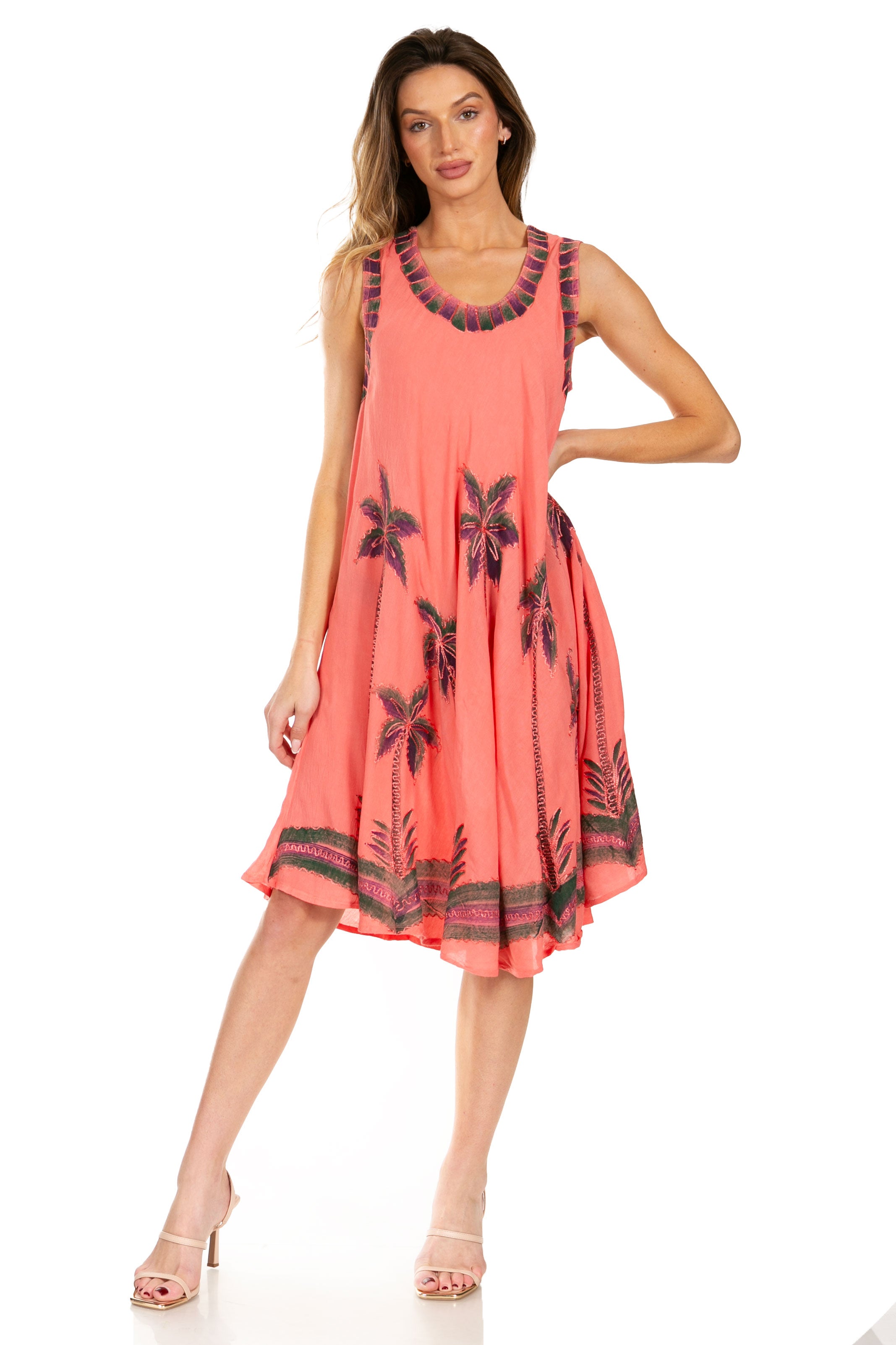 Woman wearing a coral dress with black floral patterns on a white background