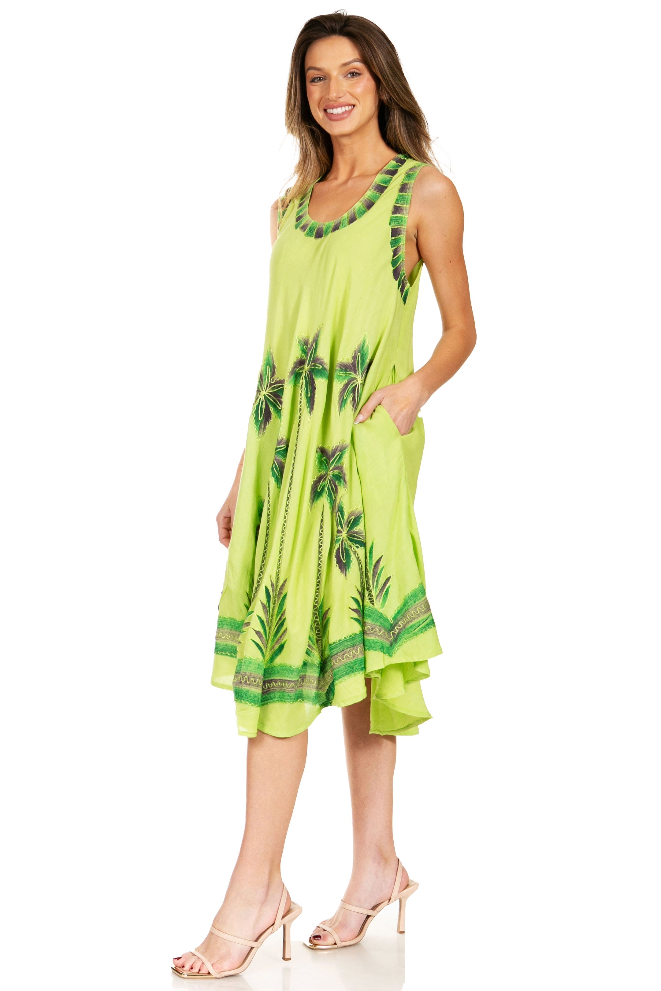 Woman wearing a bright green dress with palm tree pattern on a white background