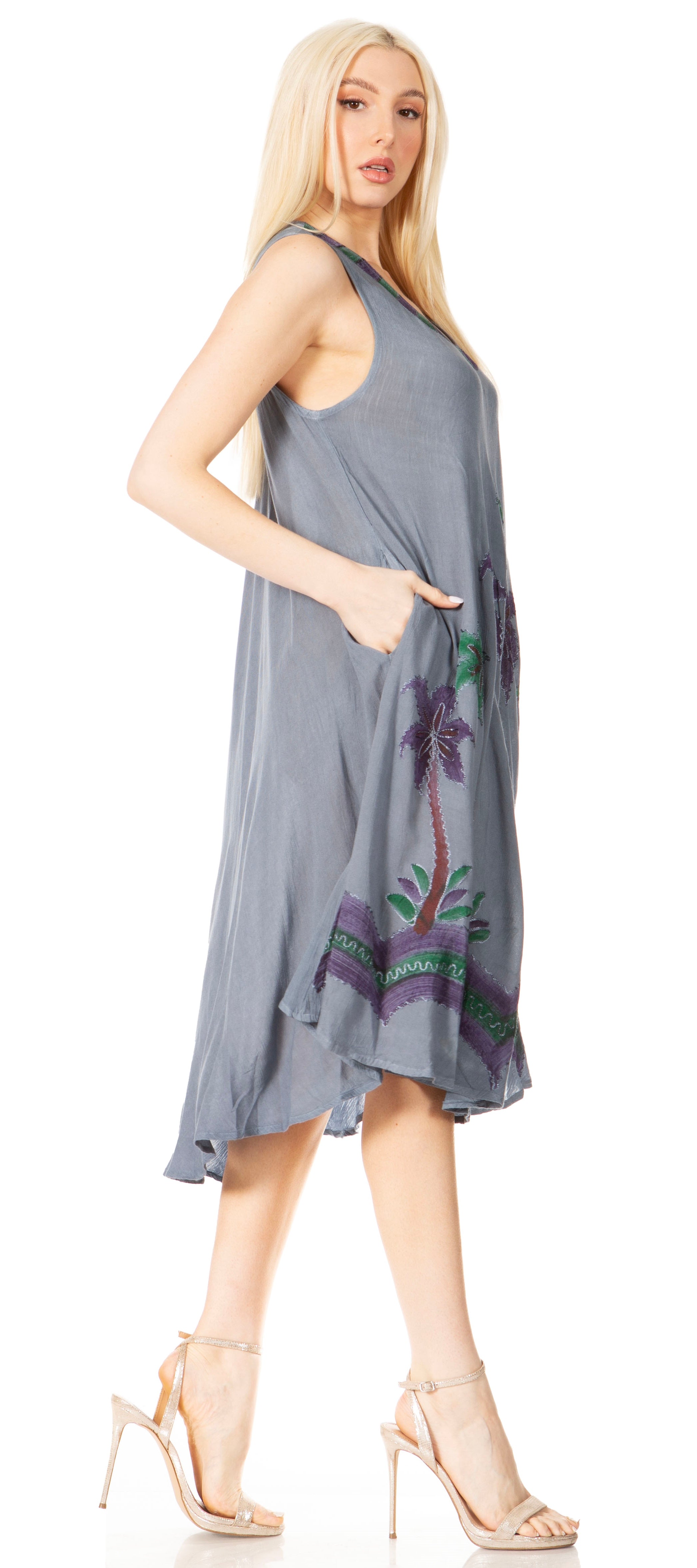 Woman wearing a gray dress with floral embroidery on a white background