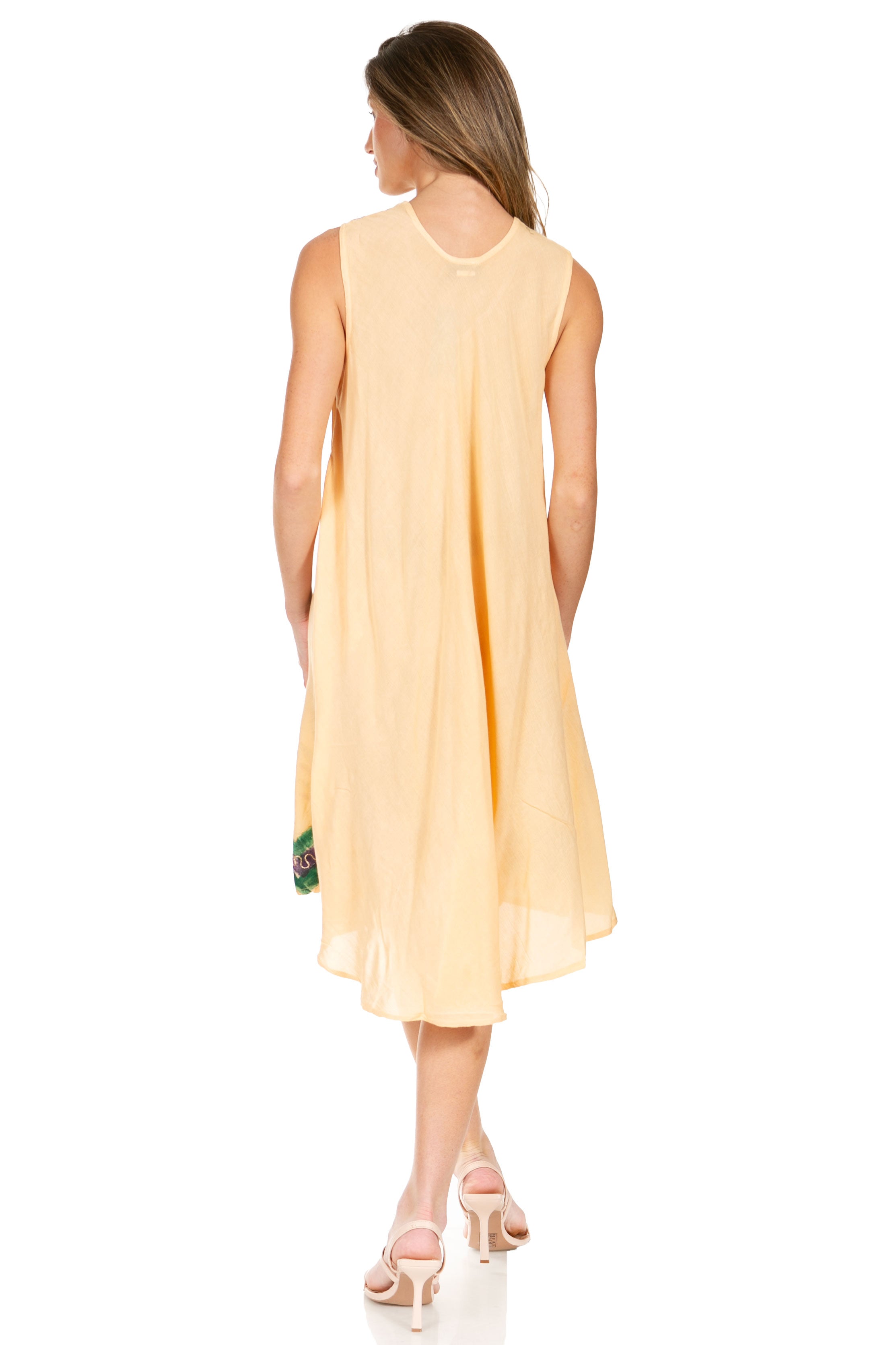 Woman wearing a yellow dress with floral details on a white background