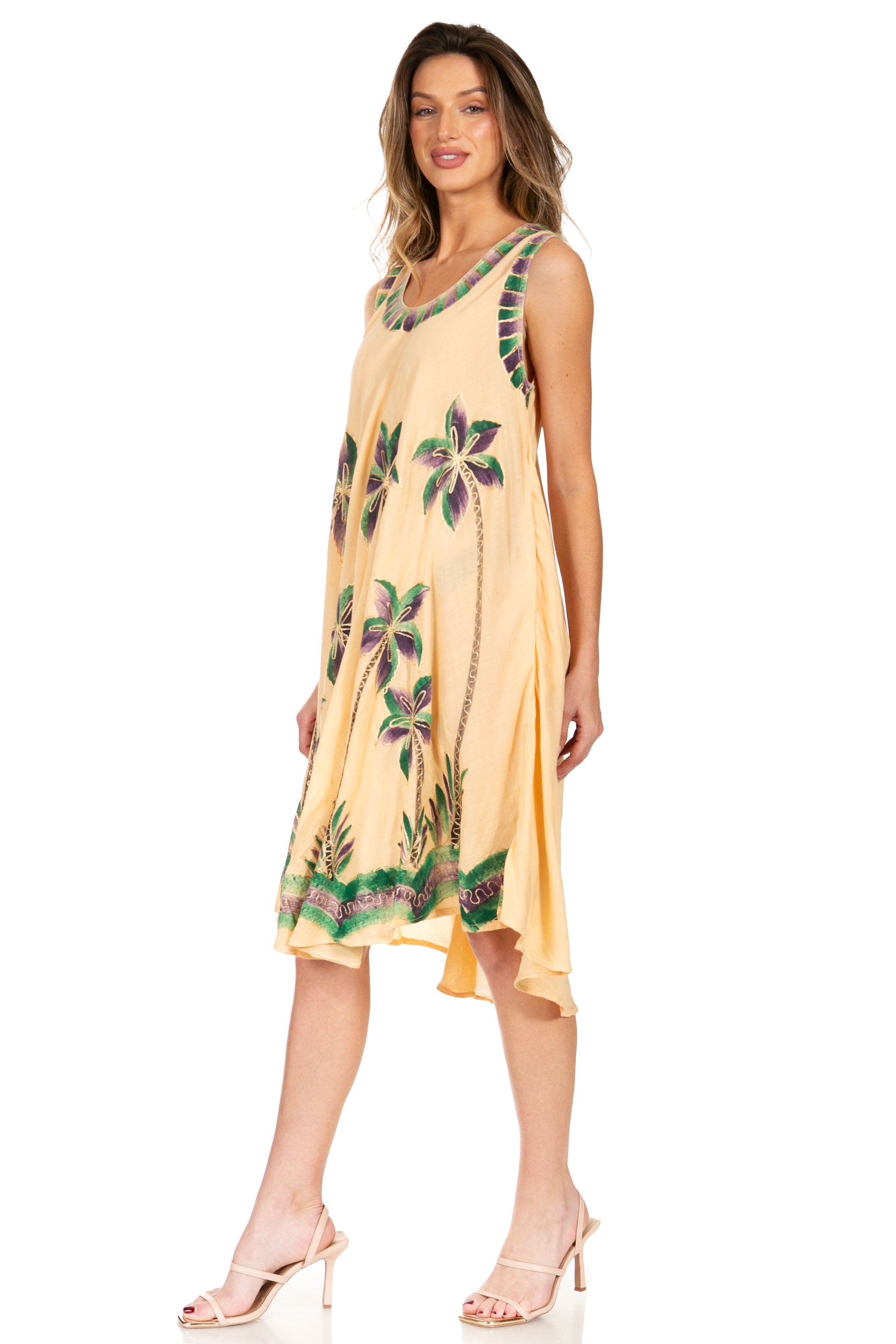Woman wearing a yellow dress with floral pattern on a white background