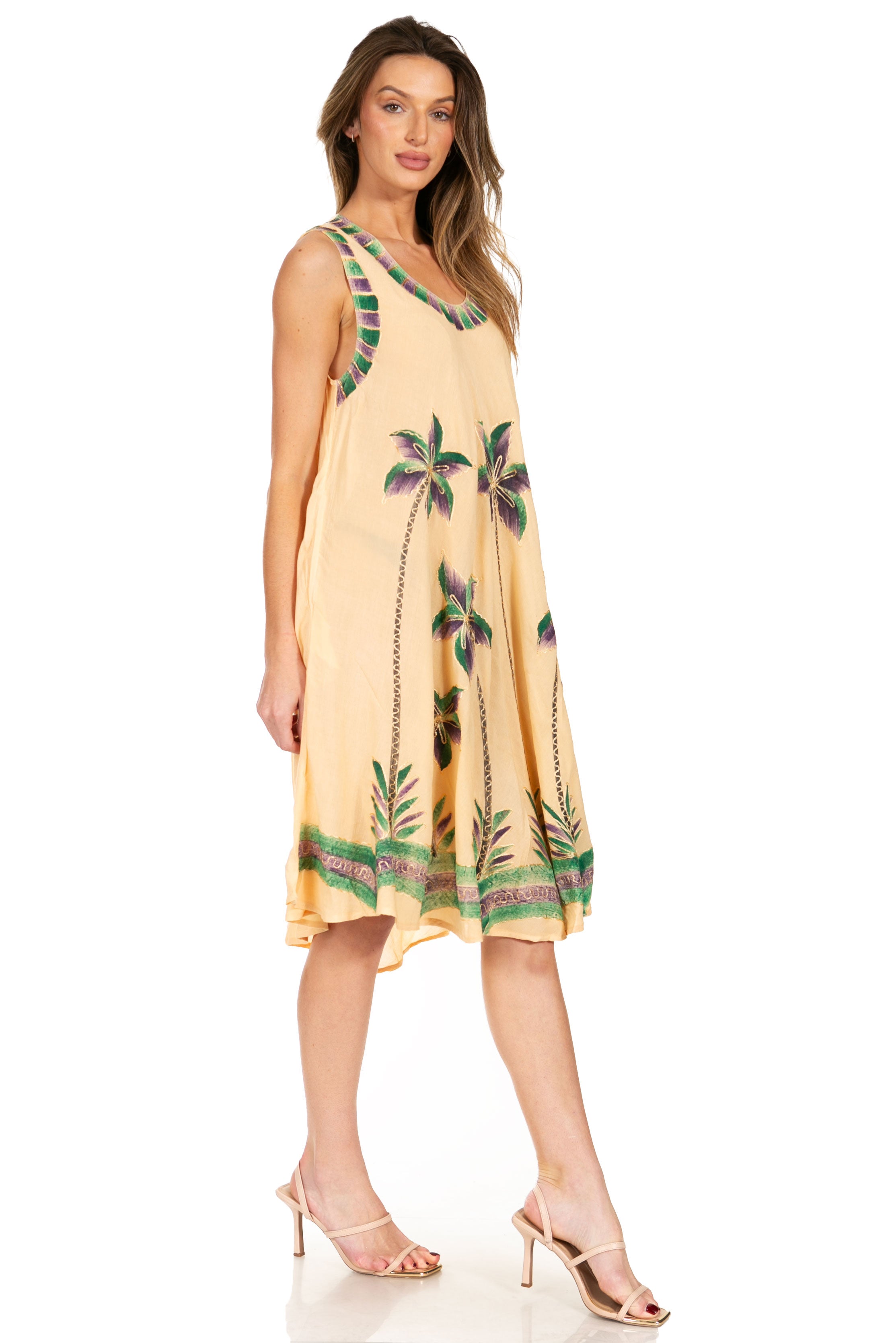 Woman wearing a yellow dress with palm tree pattern on a white background