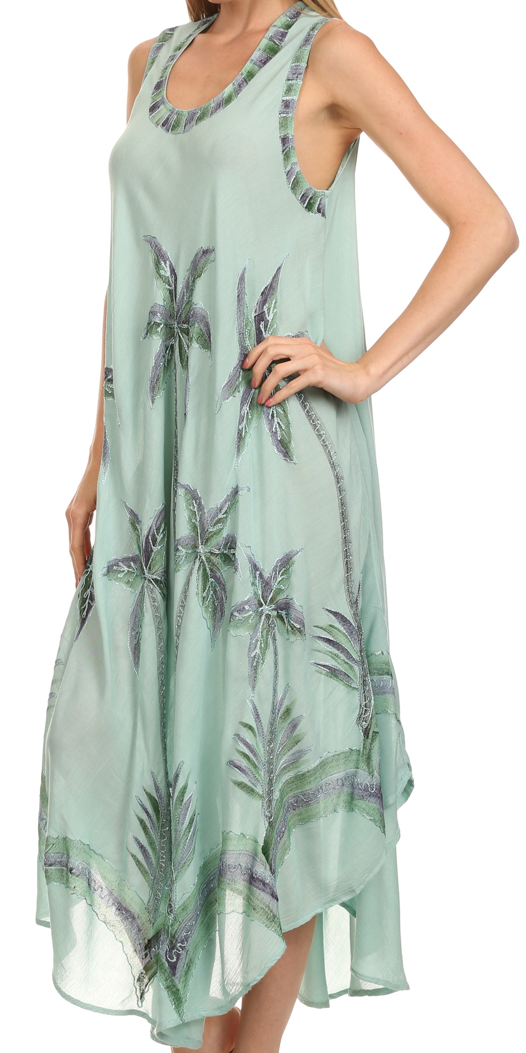 Woman wearing a light green dress with floral patterns on a white background