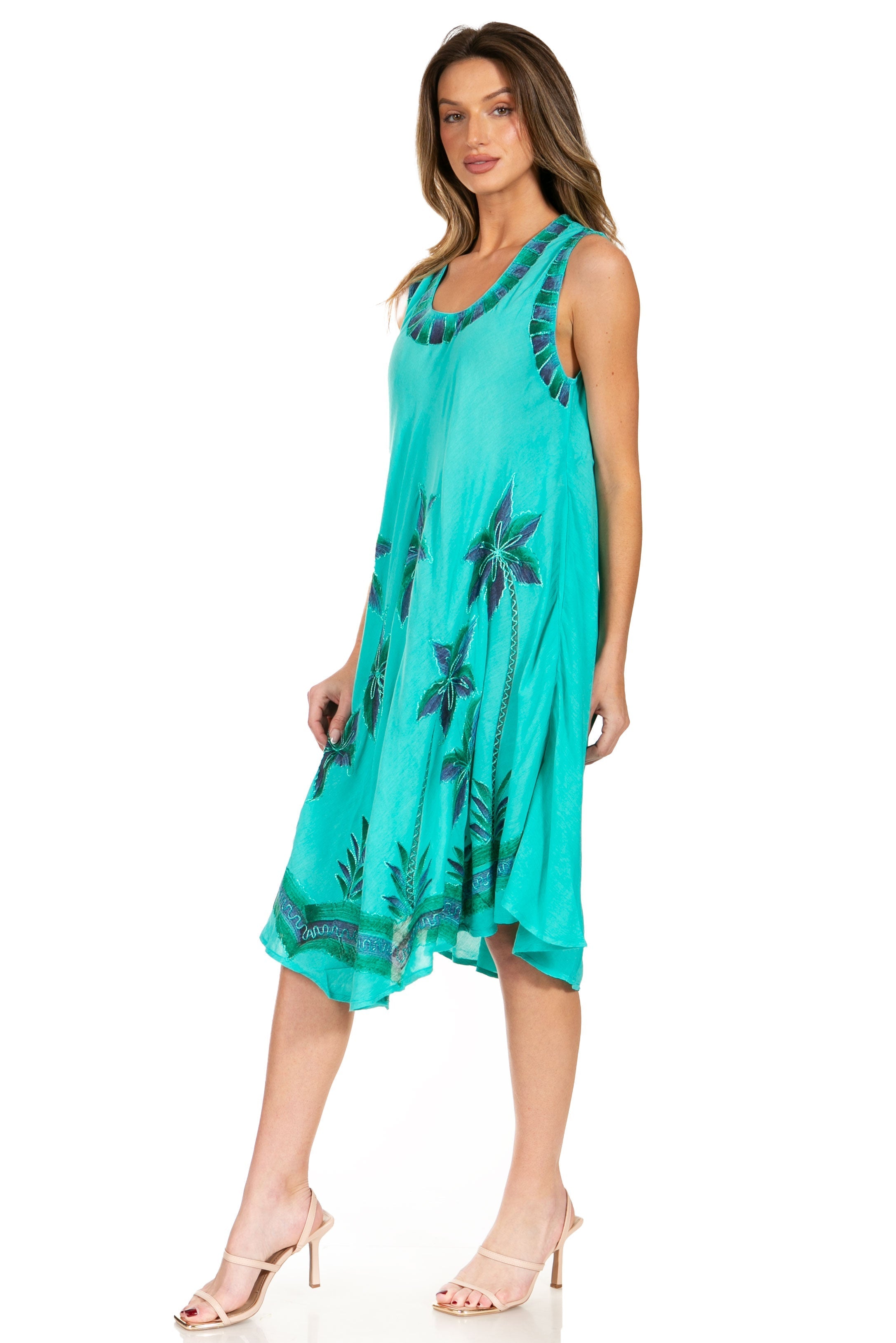 Woman wearing a turquoise dress with floral patterns on a white background