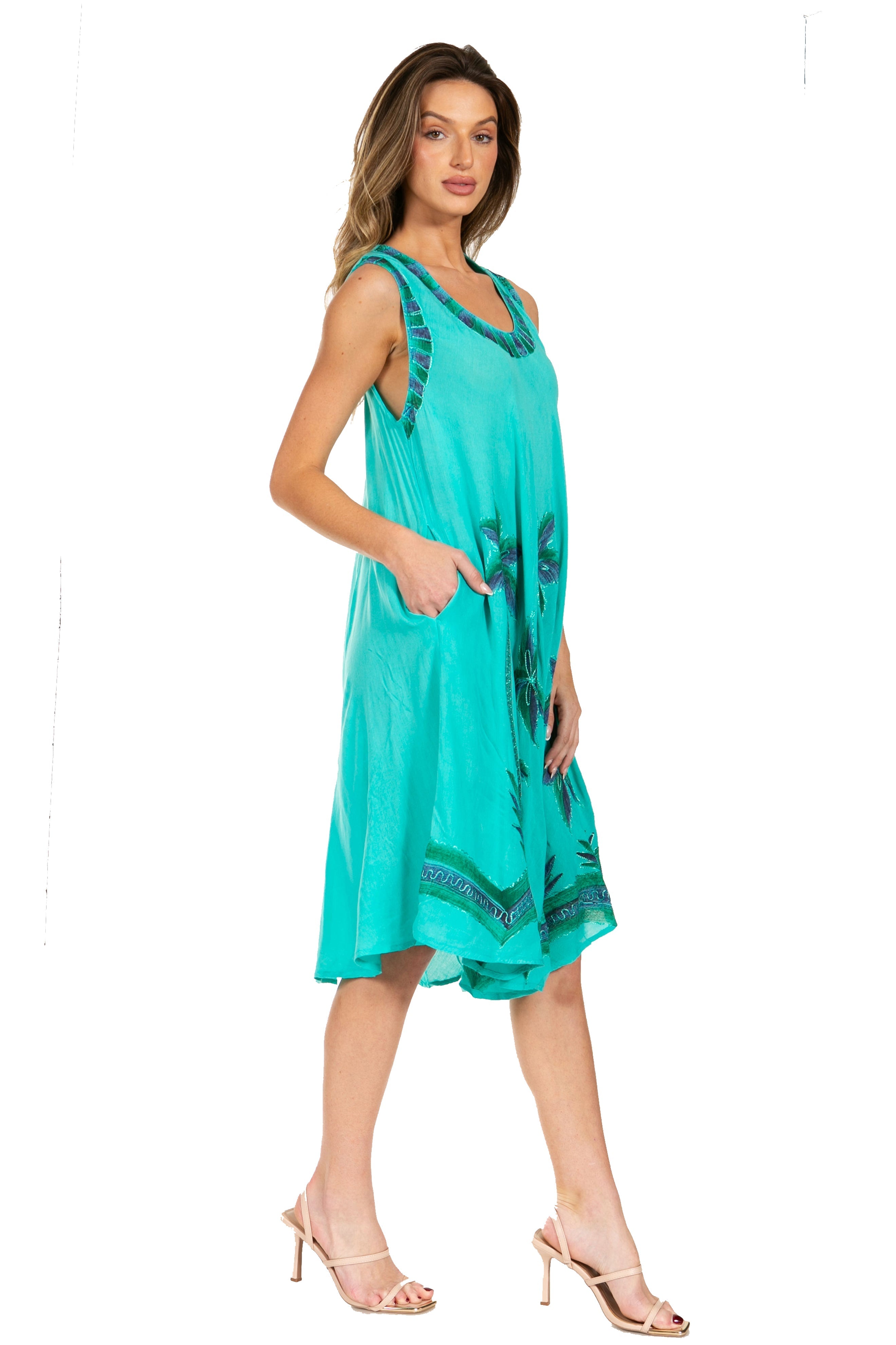 Woman wearing a turquoise dress with floral patterns on a white background