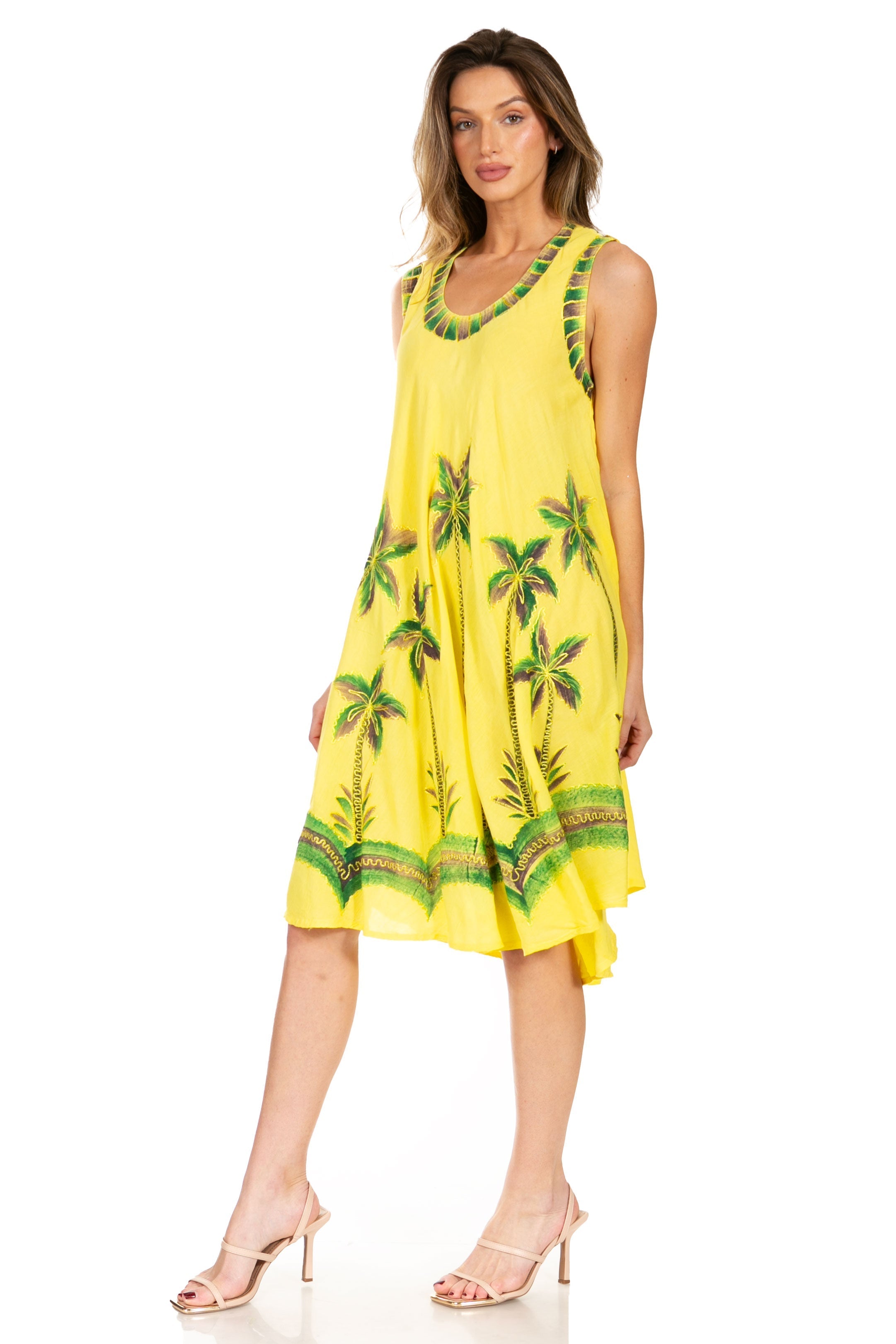 Woman wearing a yellow dress with palm tree patterns on a white background