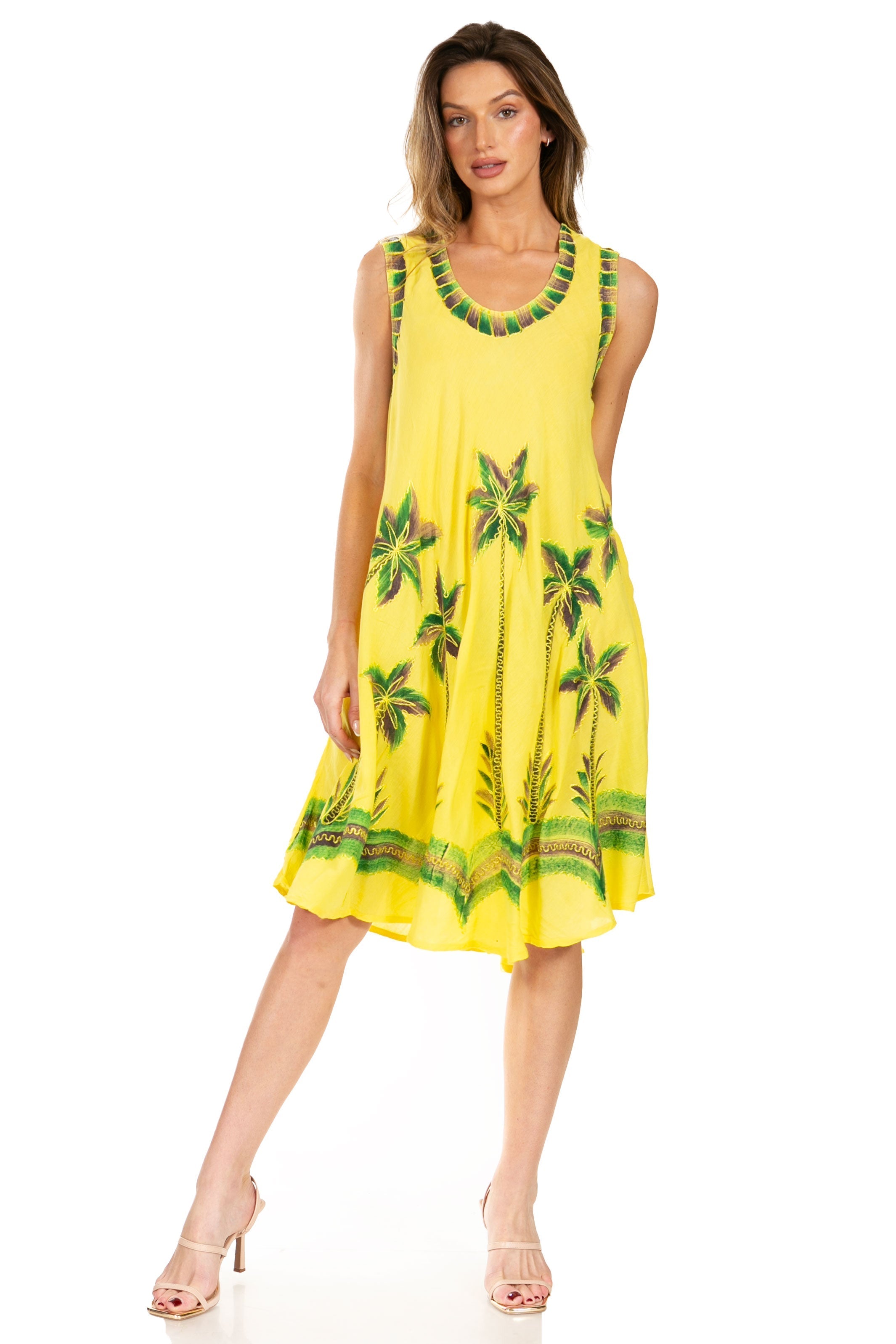 Woman wearing a yellow dress with tropical patterns on a white background