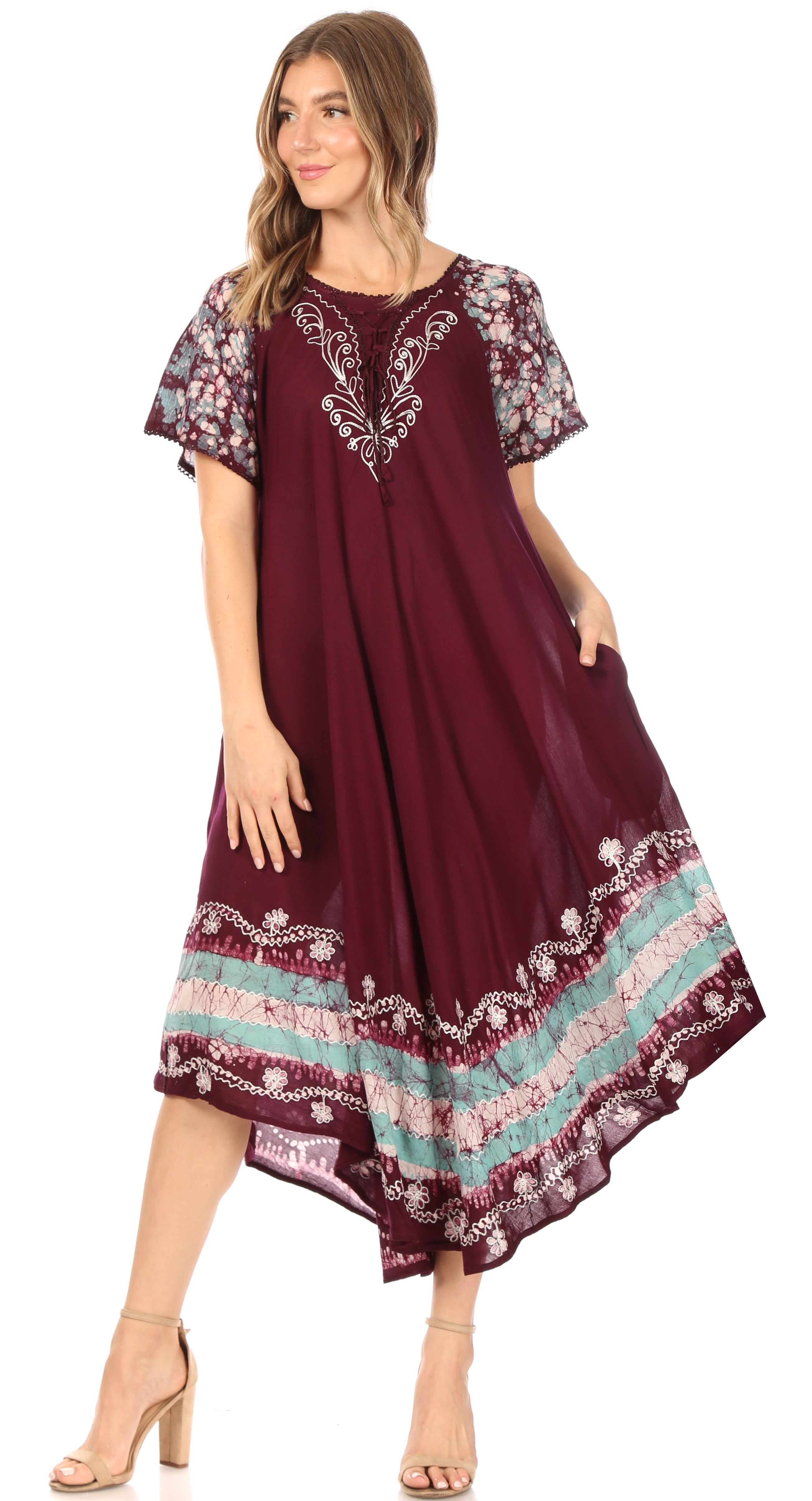 Woman wearing a burgundy dress with floral embroidery on a white background