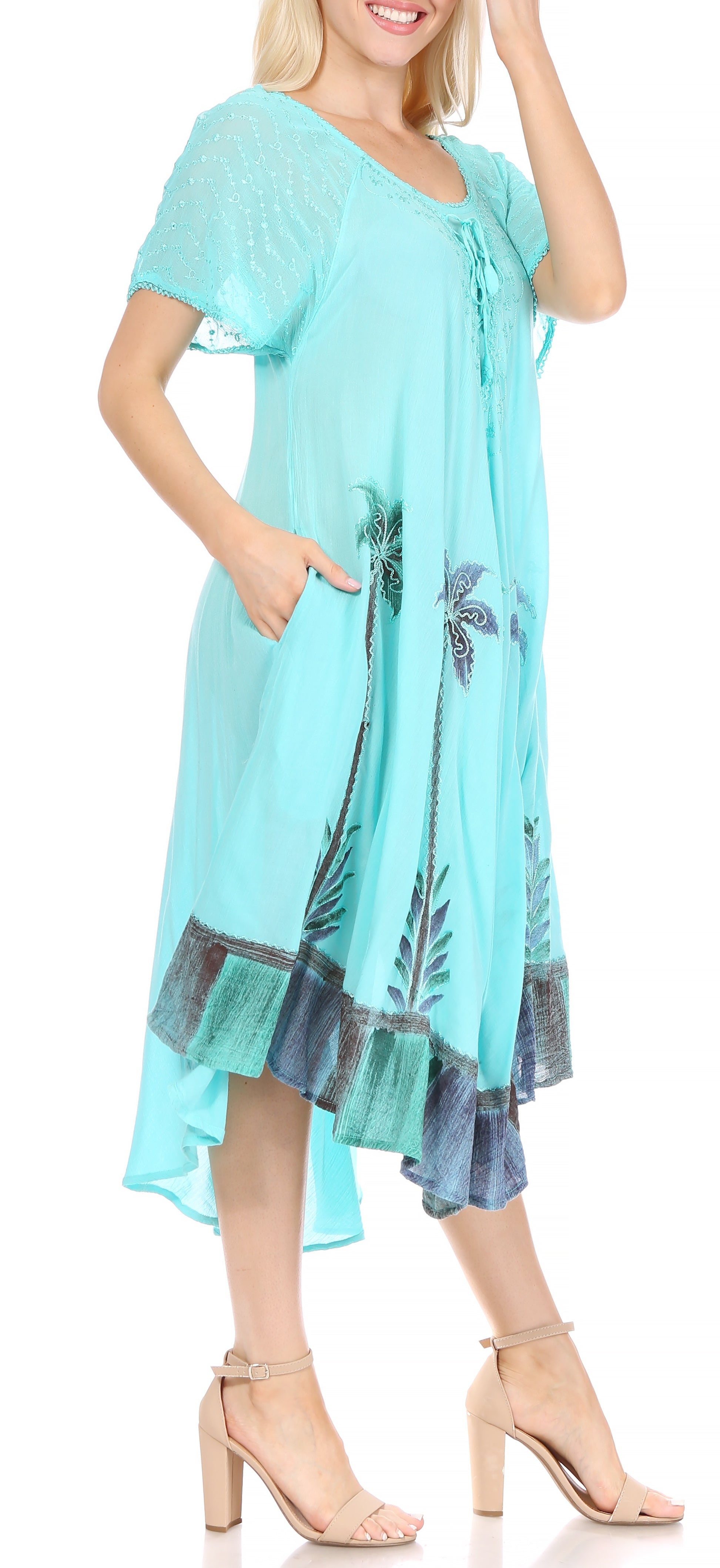 Woman wearing a turquoise dress with palm tree design on a white background