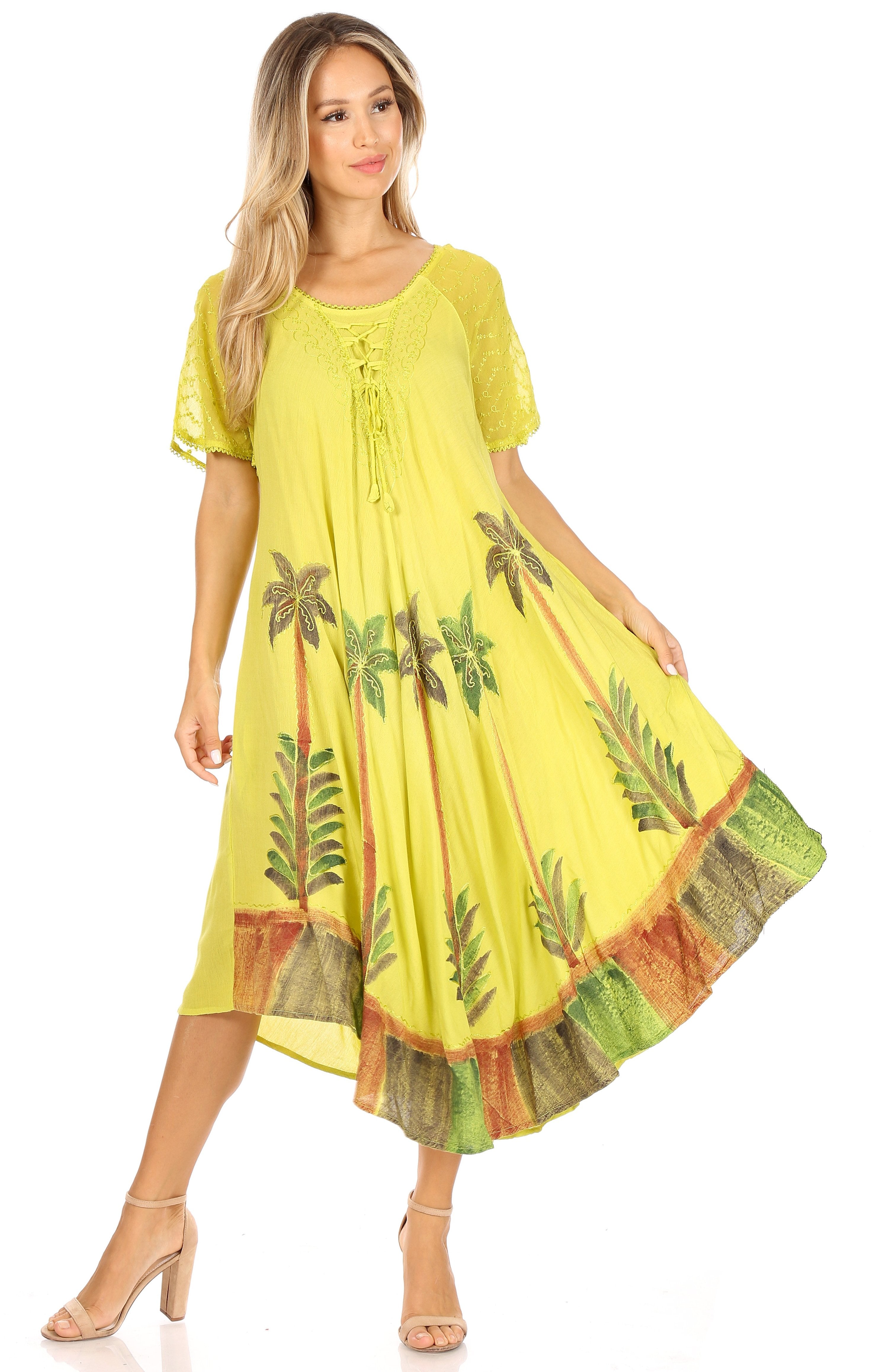 Woman wearing a yellow dress with leaf patterns on a white background