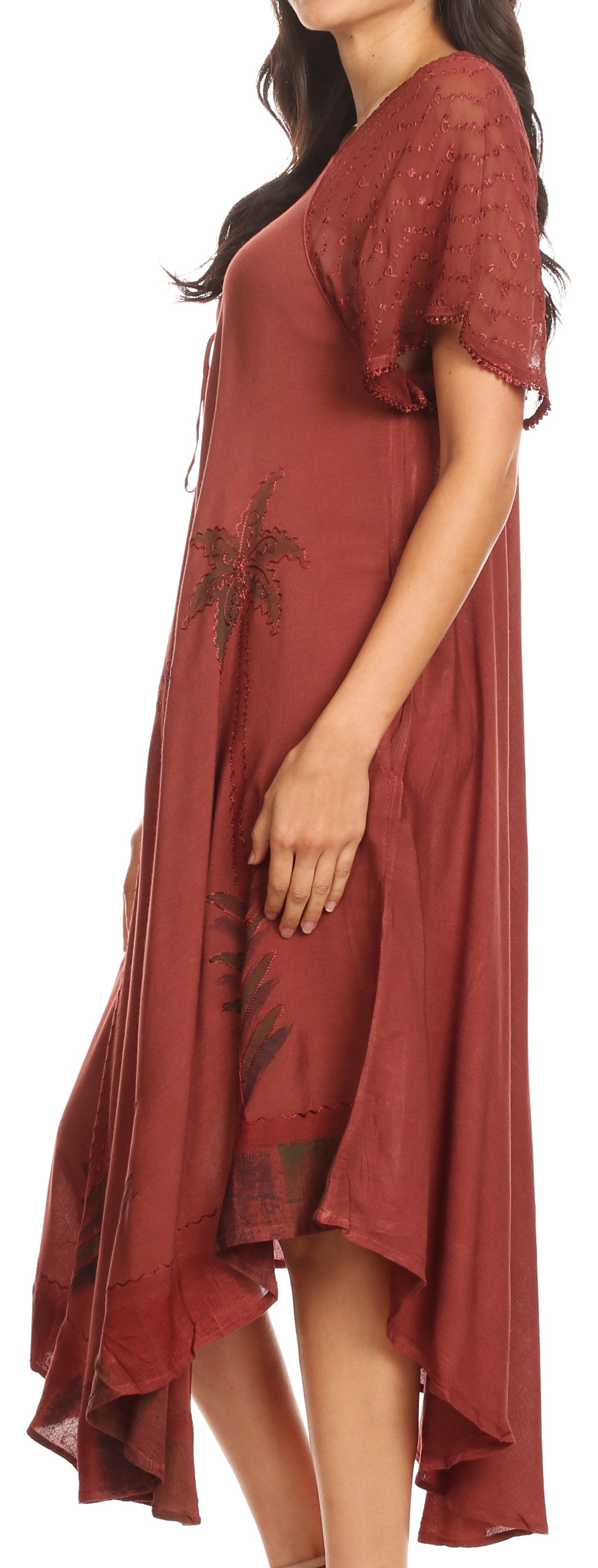 Woman wearing a rust-colored dress with floral embroidery on a white background