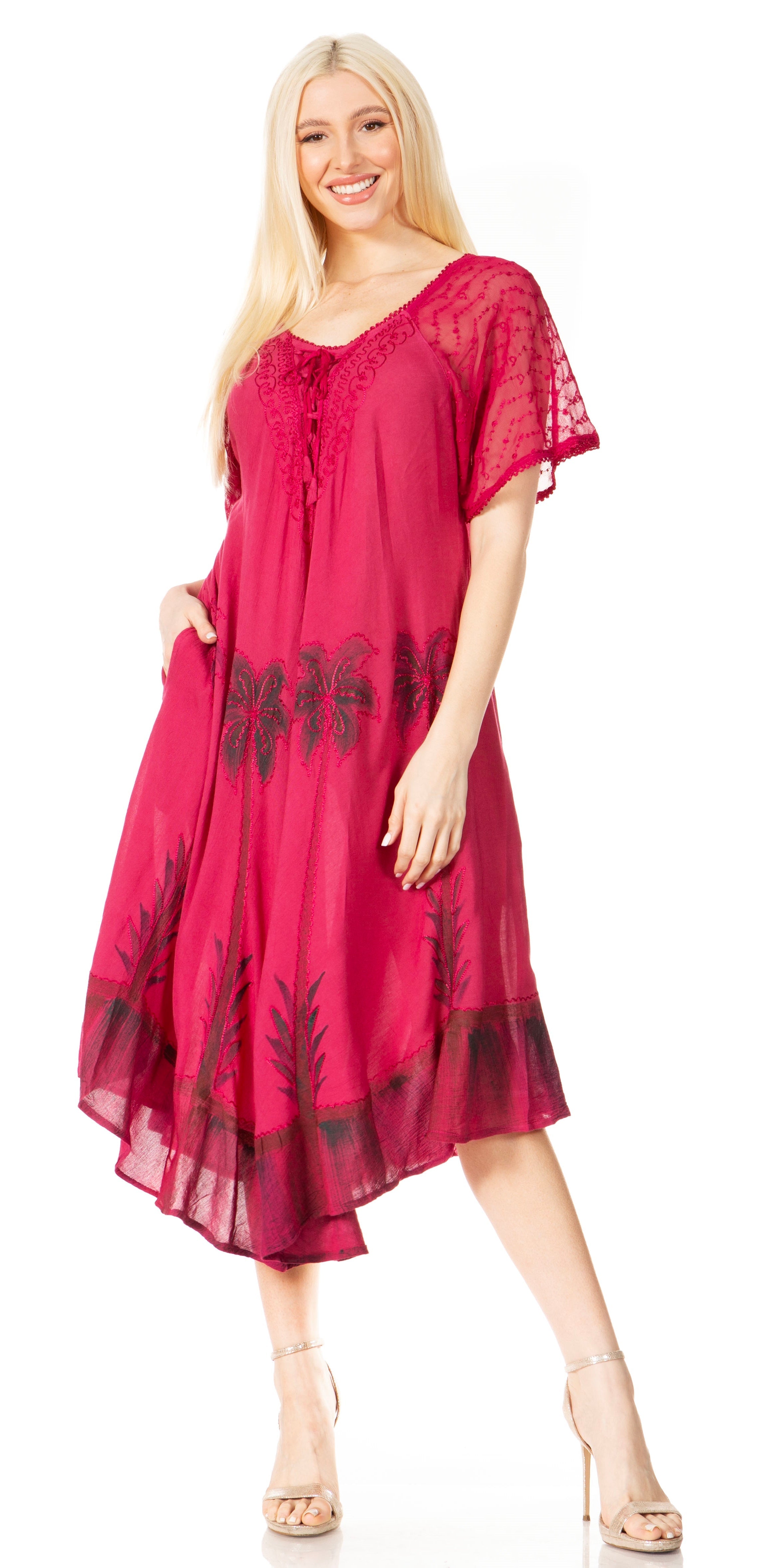 Woman wearing a pink dress with black floral patterns on a white background